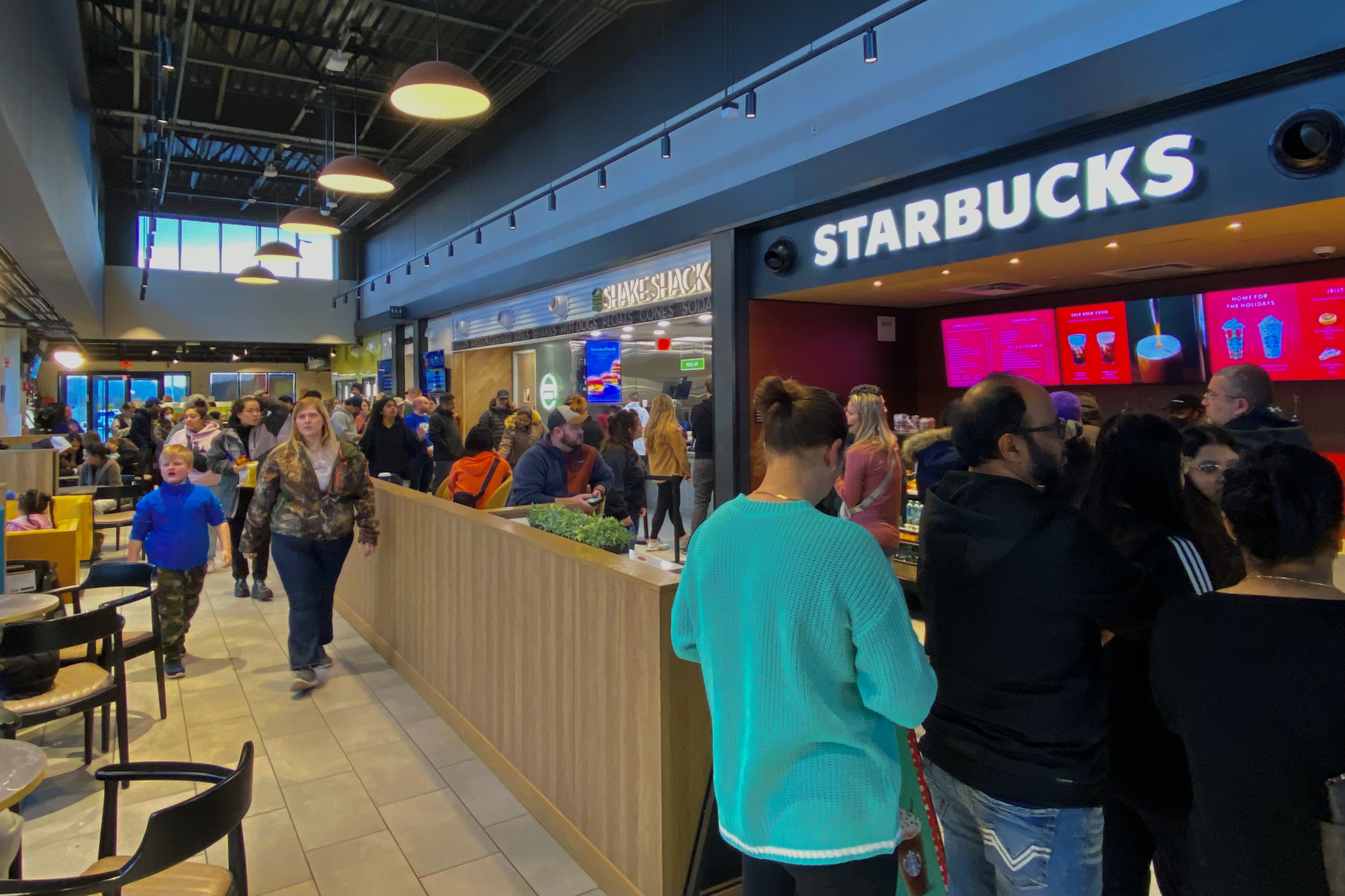 Customers line up at a Shake Shack counter inside a modern indoor dining area.