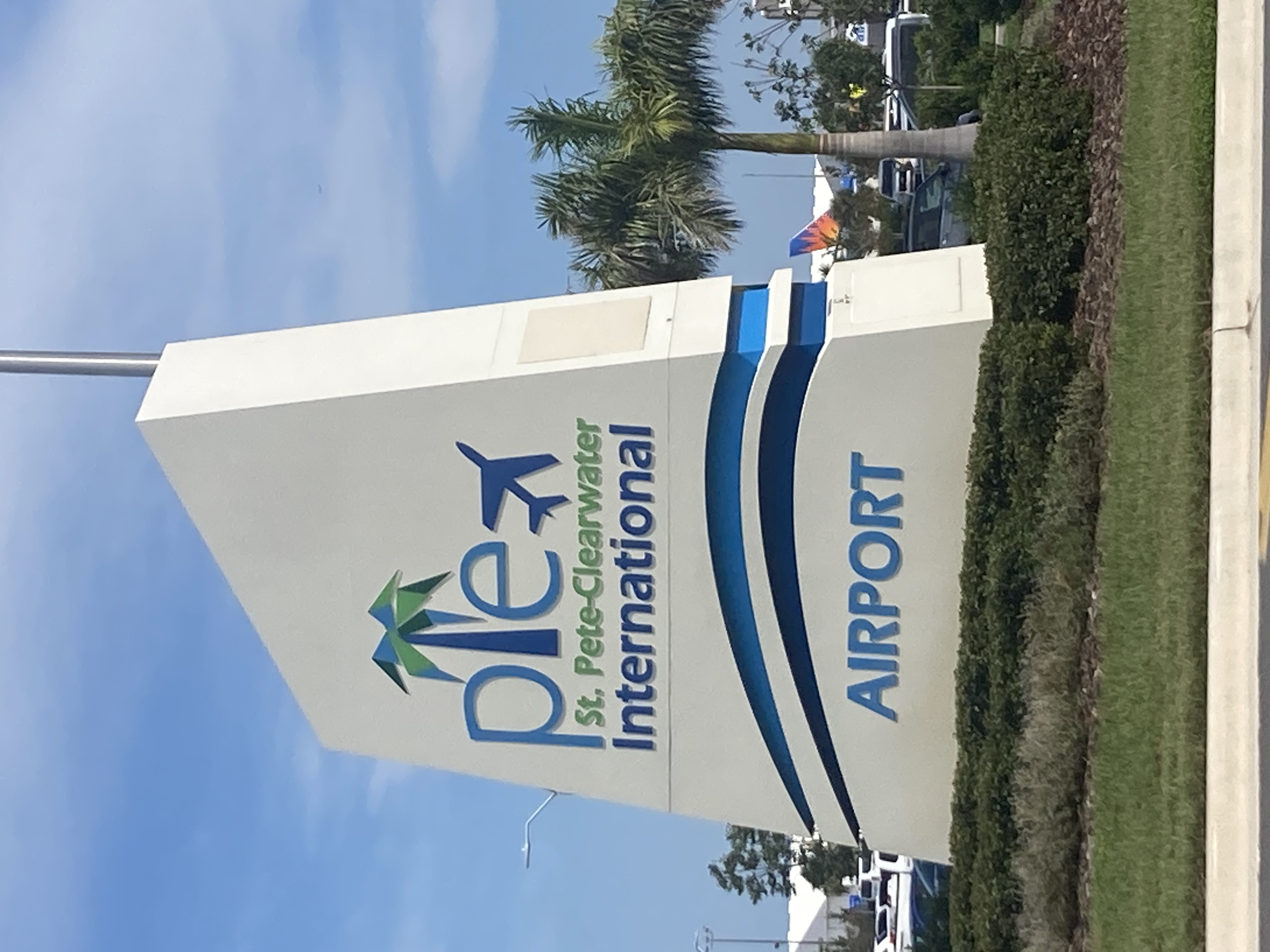 Monument sign for St. Pete-Clearwater International Airport surrounded by palm trees.