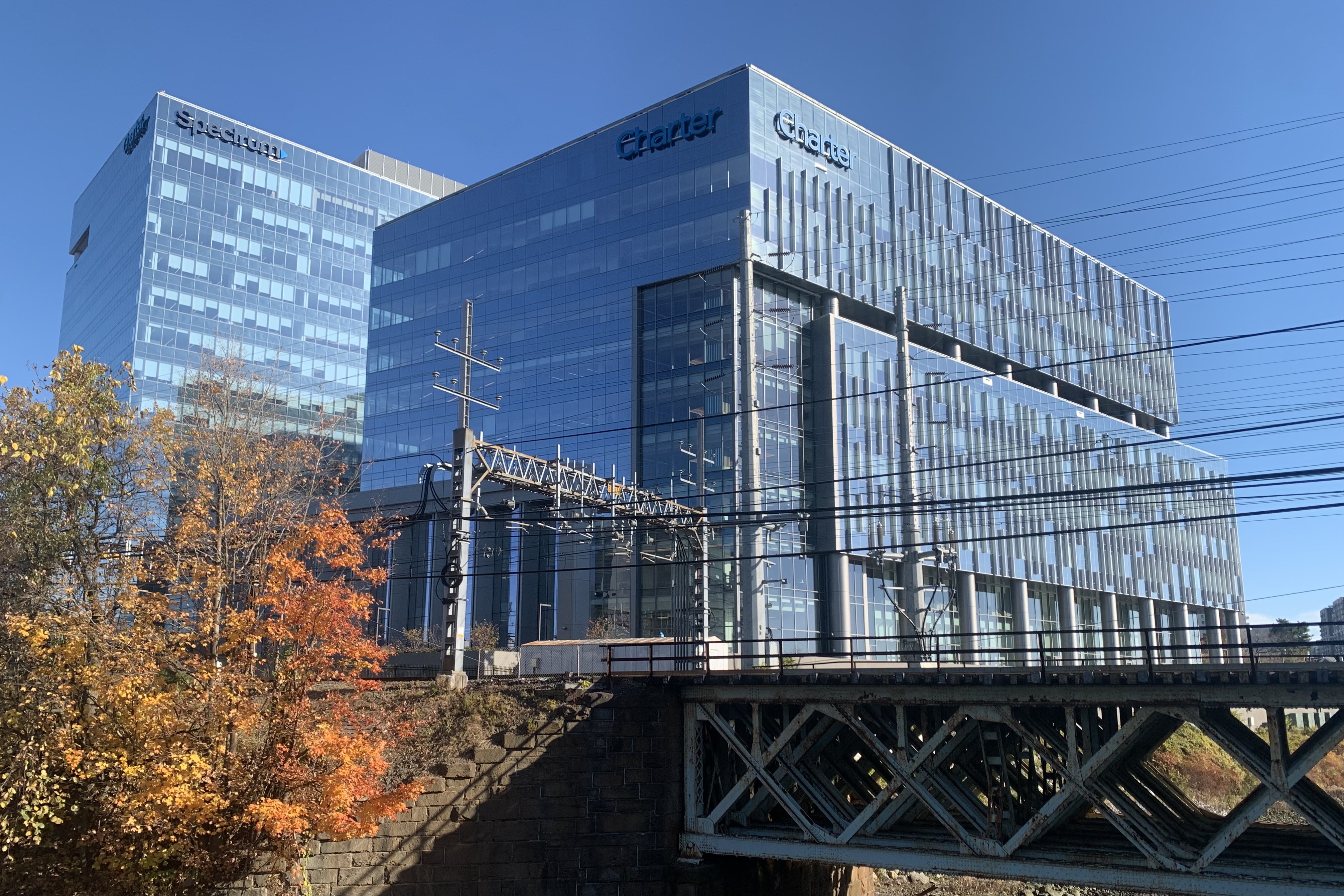 Glass office building with Charter Communications and Spectrum signage on the facade.