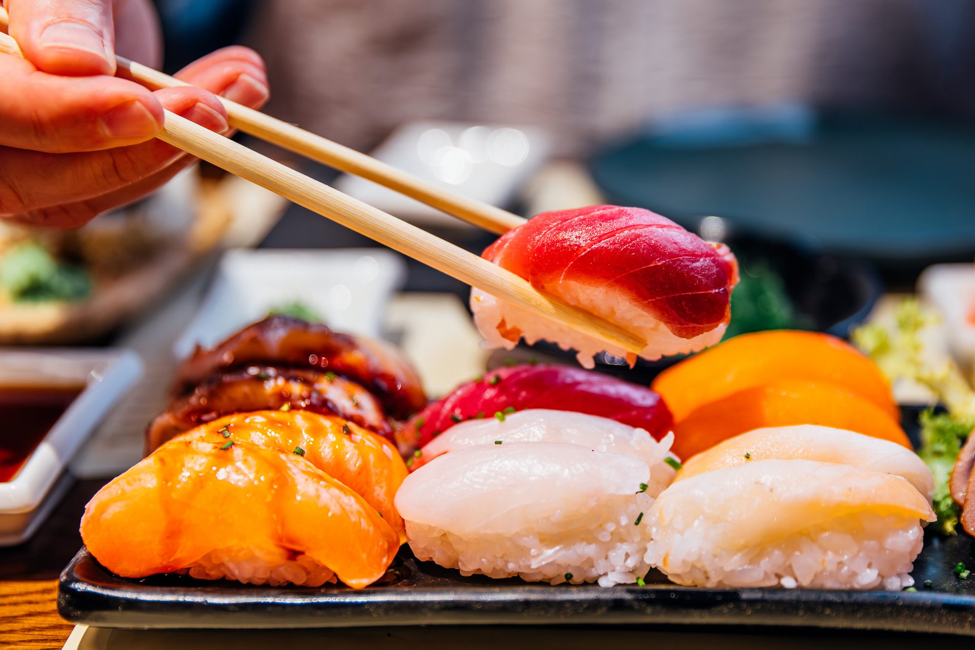 Man eating sushi at the sushi bar, close-up