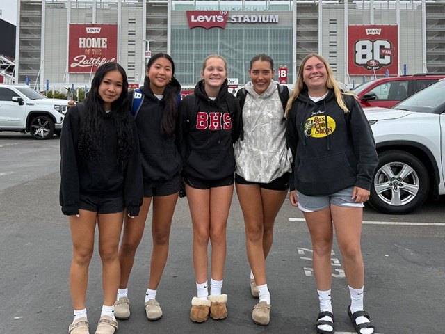 Five young women in casual clothing stand together outside Levi's Stadium.