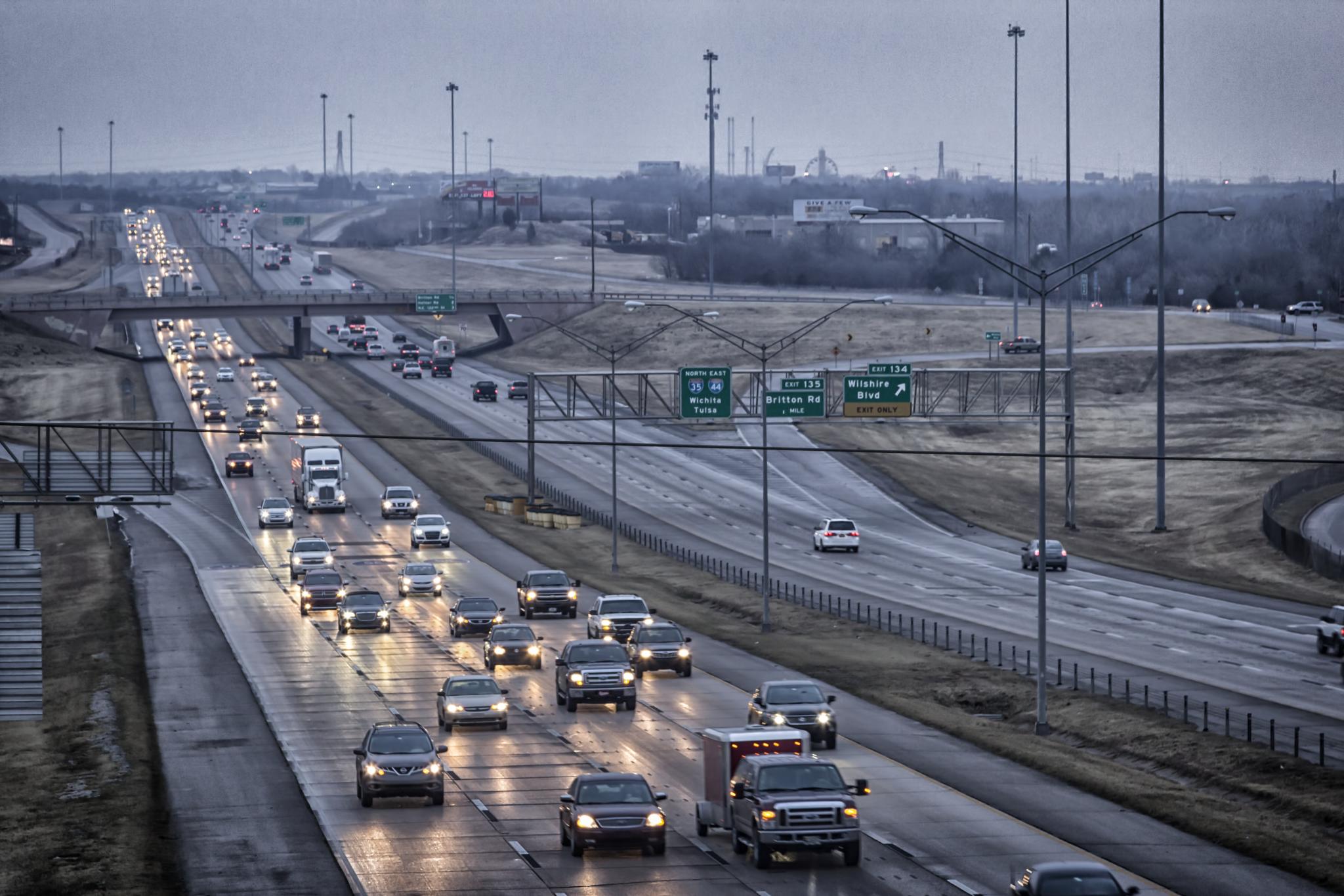Multi-lane interstate highway with heavy traffic in both directions under an overcast sky.