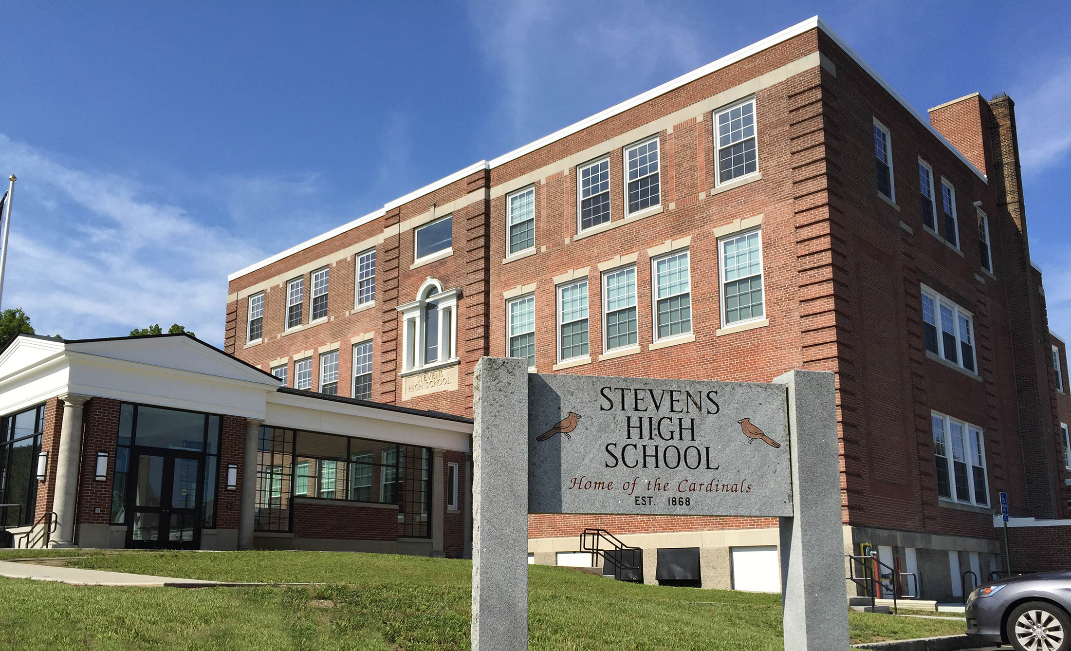 Red brick multi-story school building with a stone sign reading Stevens High School.