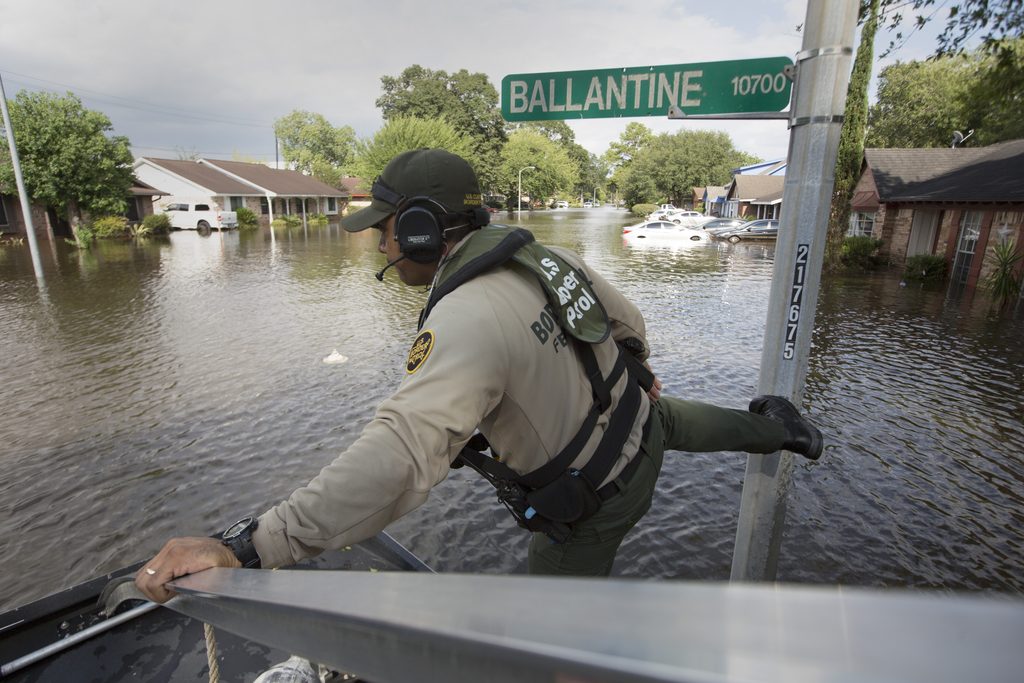 A U.S Border Patrol riverine agent fends off from a street sign as he and a cohort evacuate residents in a flooded neighborhood of Houston, Texas, after Hurricane Harvey August 30, 2017. U.S. Customs