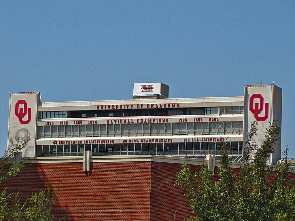 Stadium press box facade displaying university name, team logos, and championship year listings.