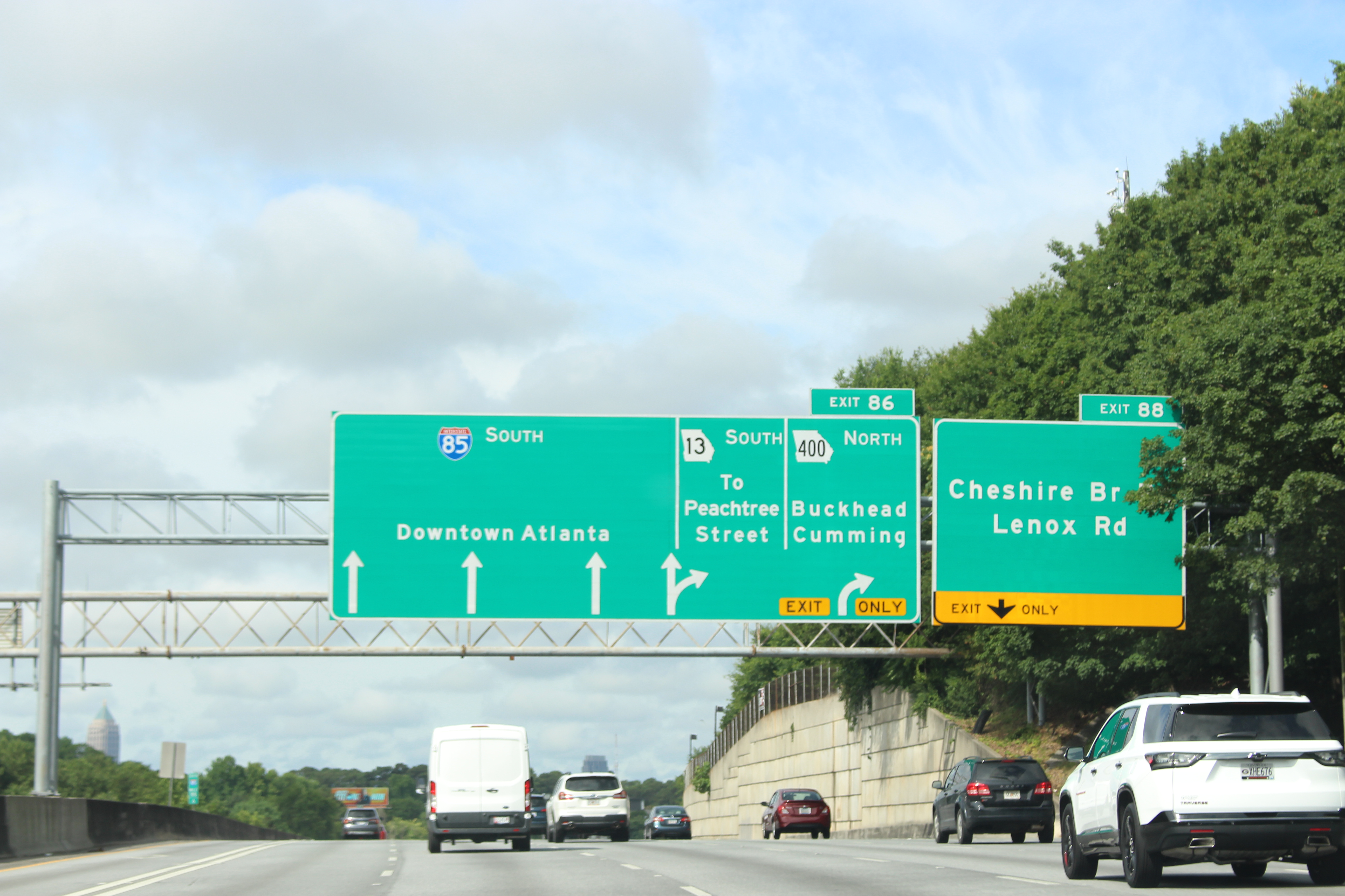 Multi-lane highway with green overhead signs indicating GA-400 North toward Buckhead and Cumming.