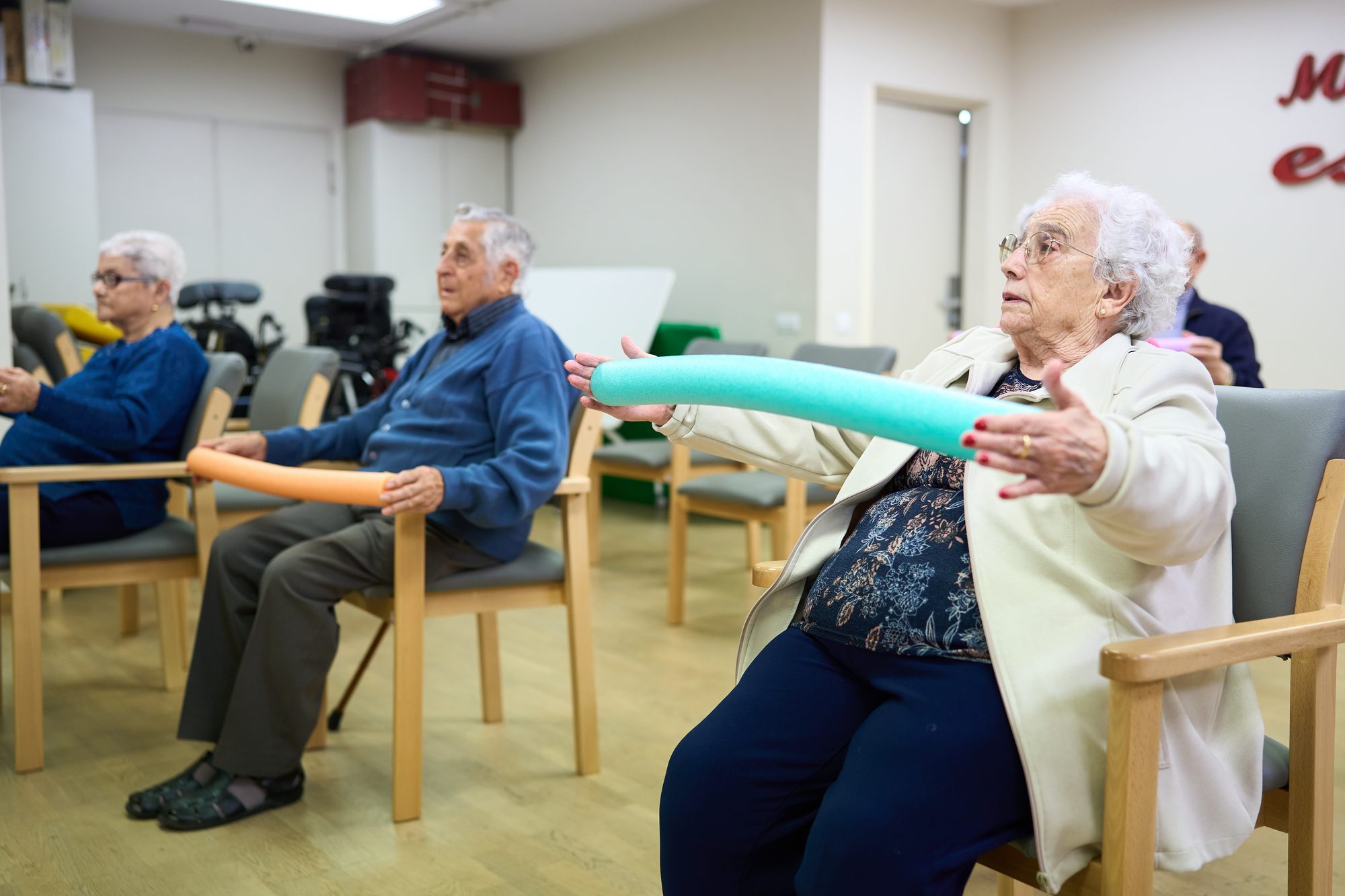Elderly People Sitting in Chairs Doing Exercises