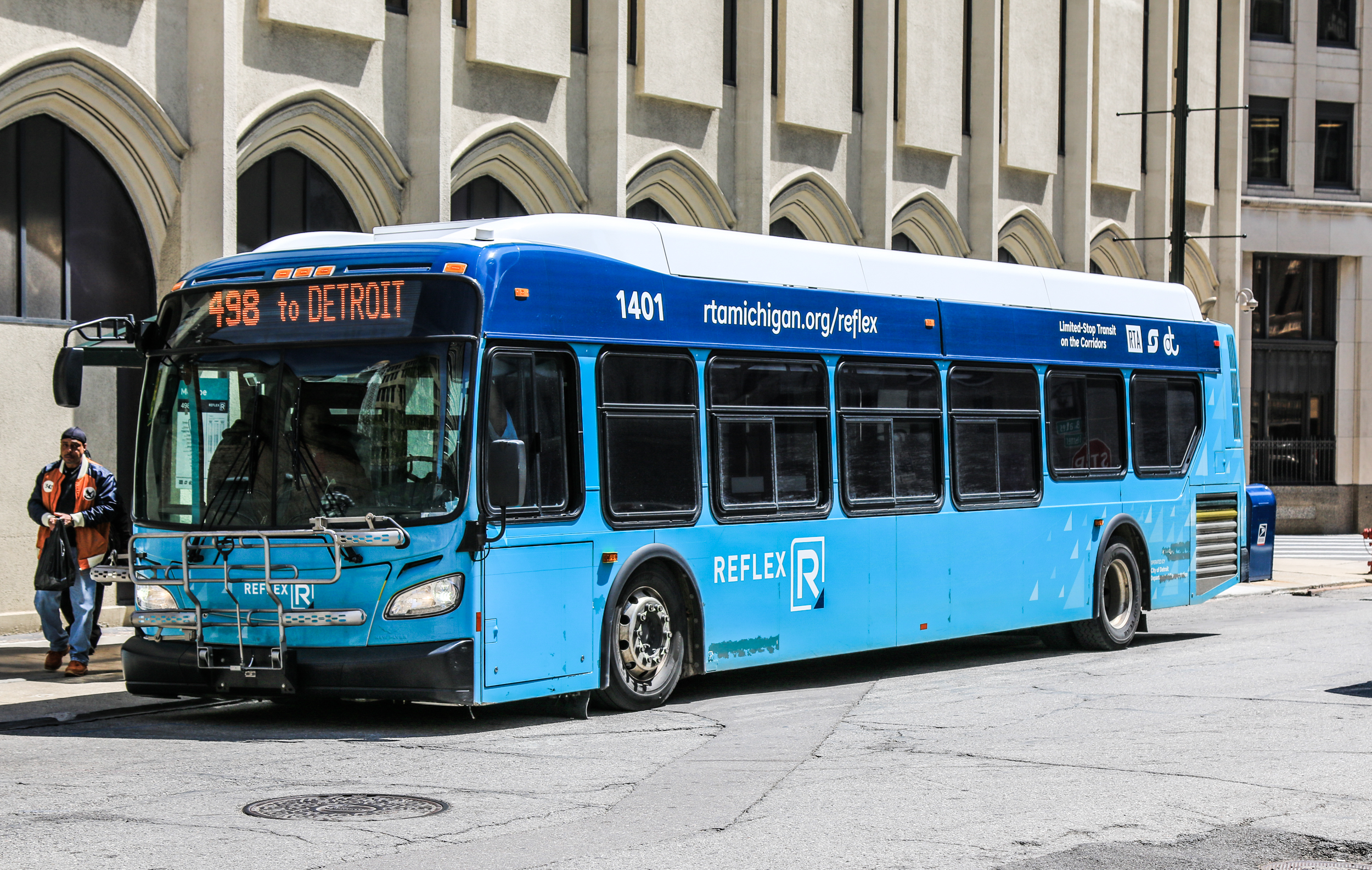 Blue RTA of Southeast Michigan bus stopped on a city street, destination sign reading to Detroit.