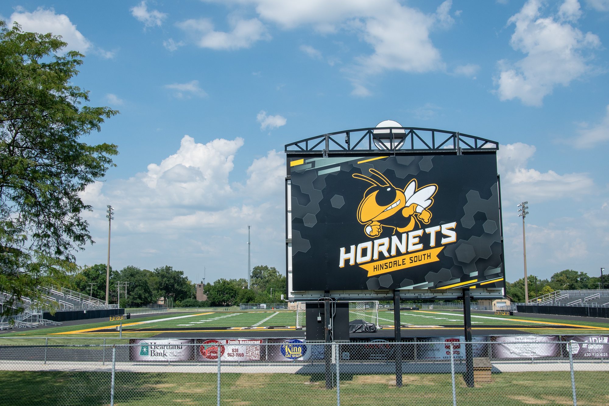 Large LED scoreboard displaying Hornets mascot logo at a high school football field