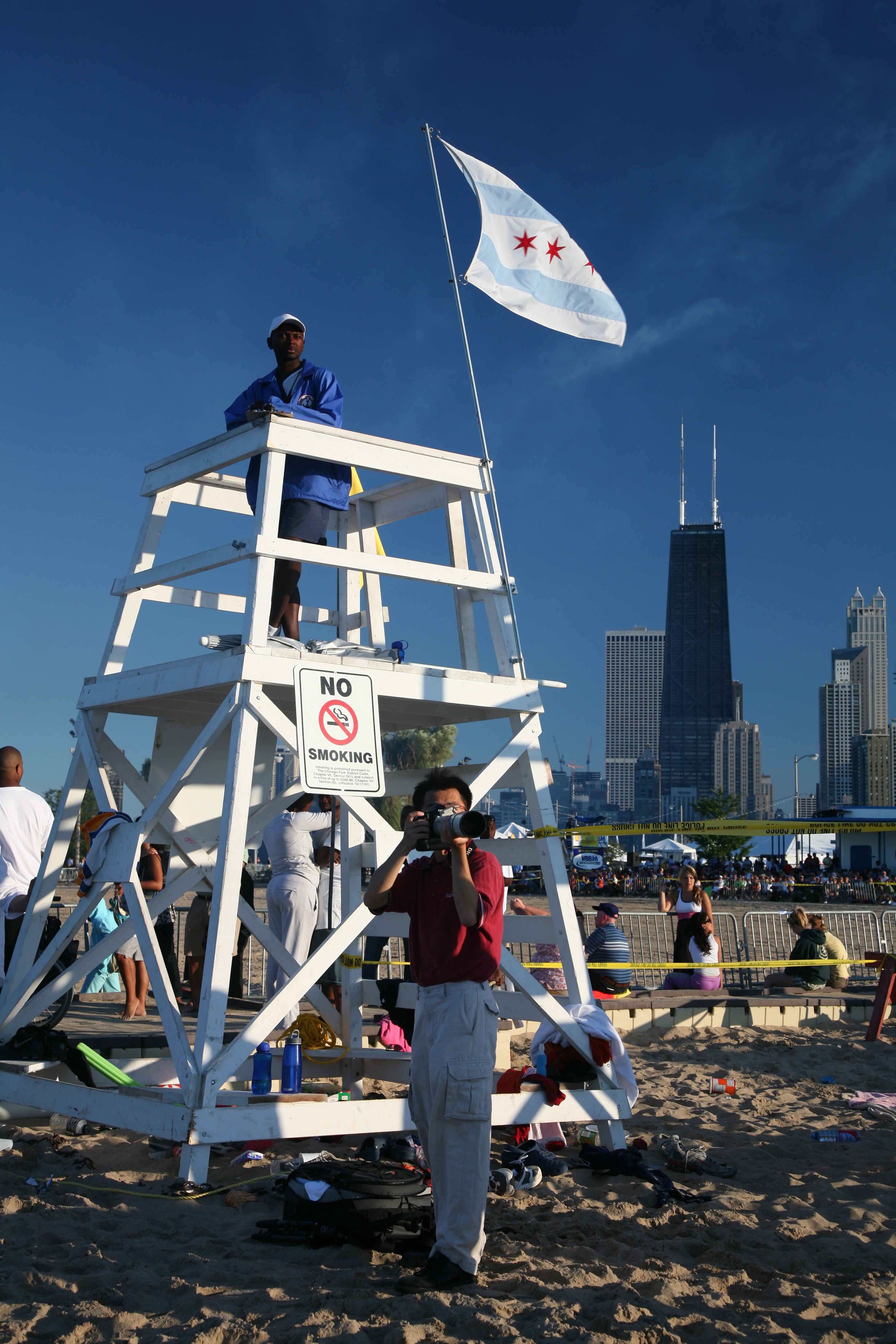 Lifeguard stand on a sandy beach with a No Smoking sign attached.