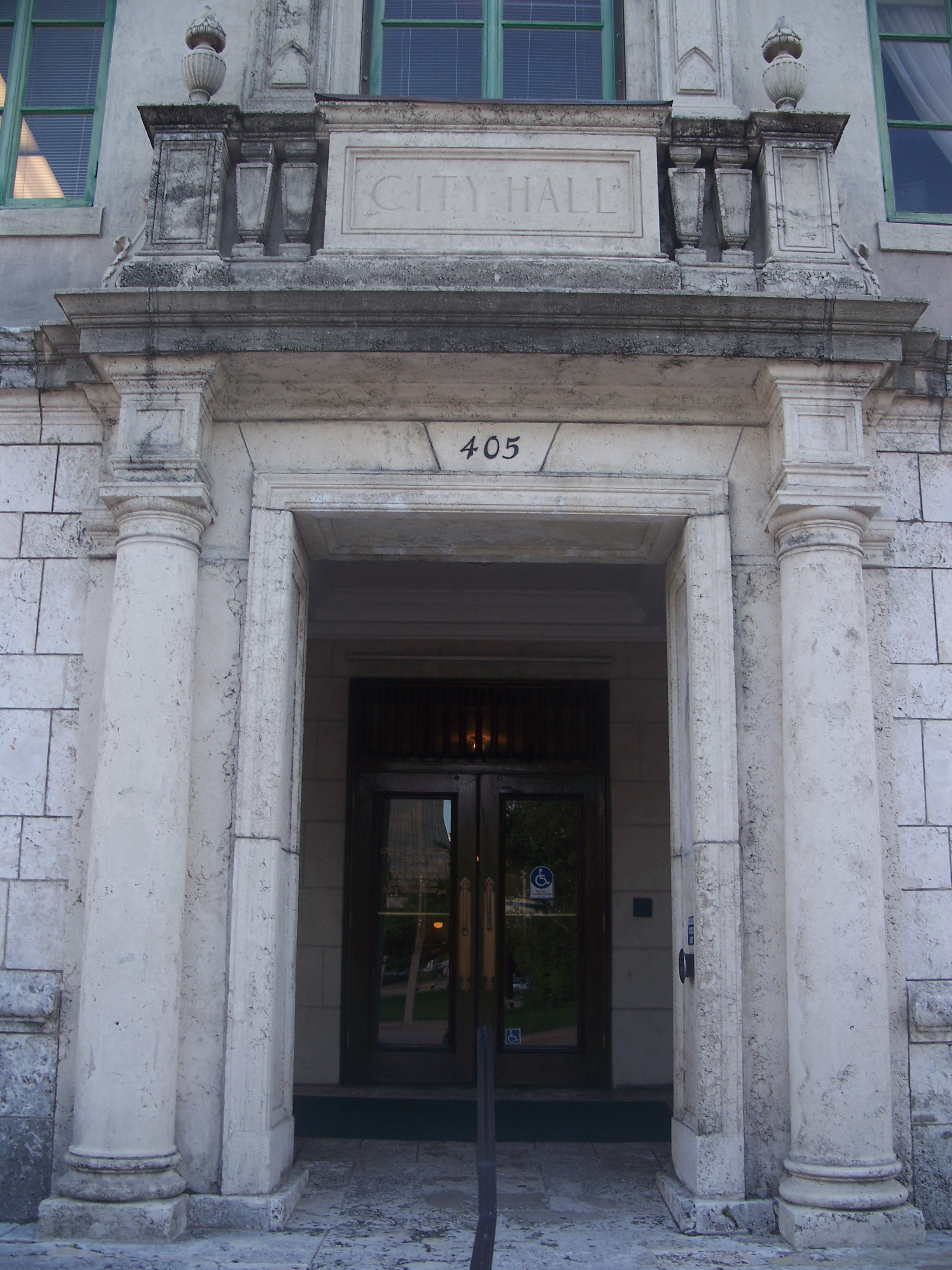 Stone entrance portico of a government building with classical columns and 'City Hall' inscription.