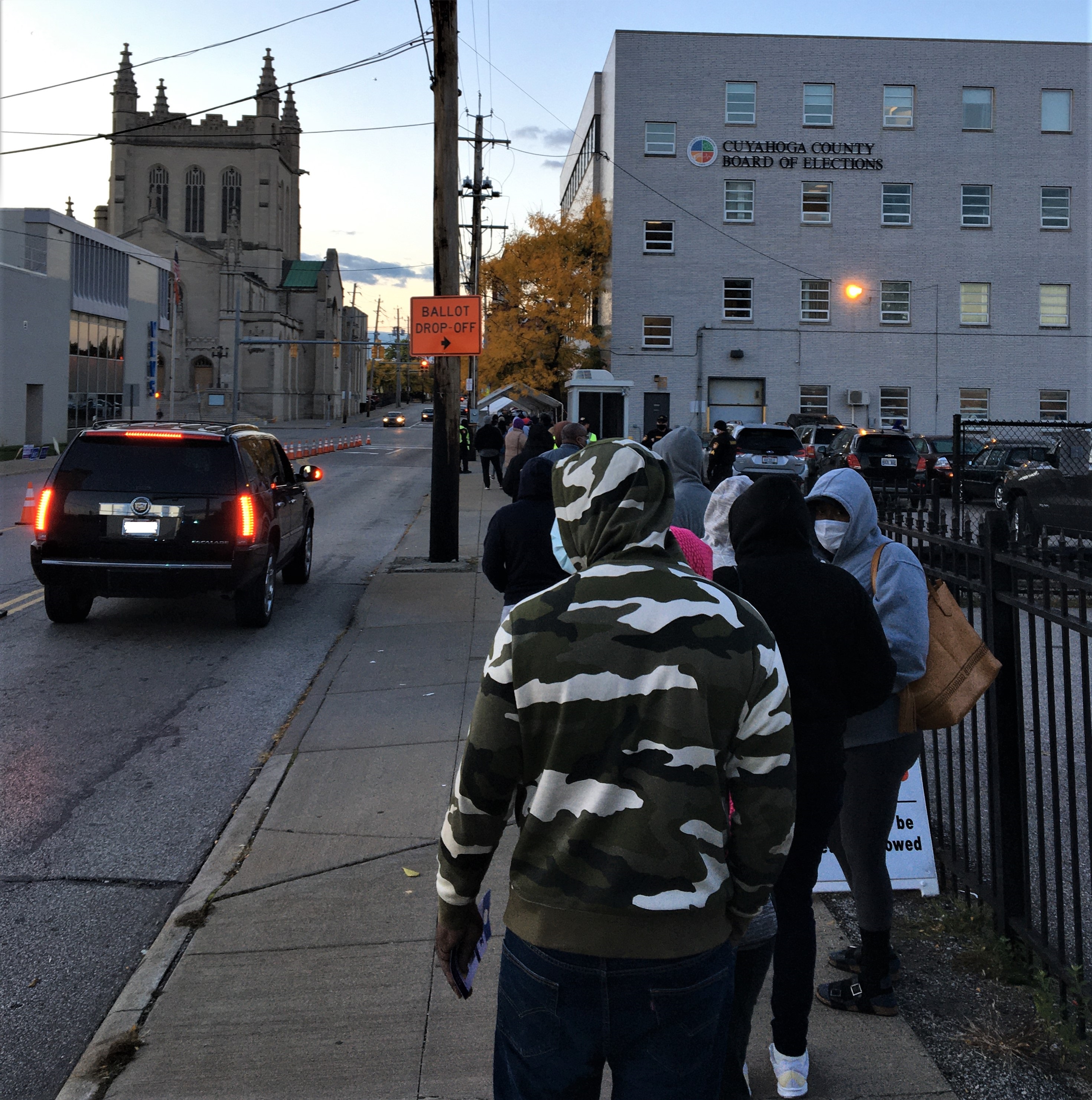 A line of people on a sidewalk outside the Cuyahoga County Board of Elections building.