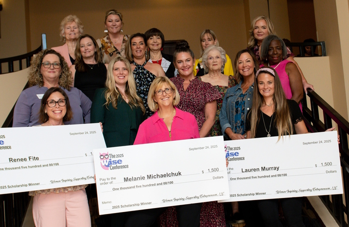 Women stand with scholarship awards holding big checks.
