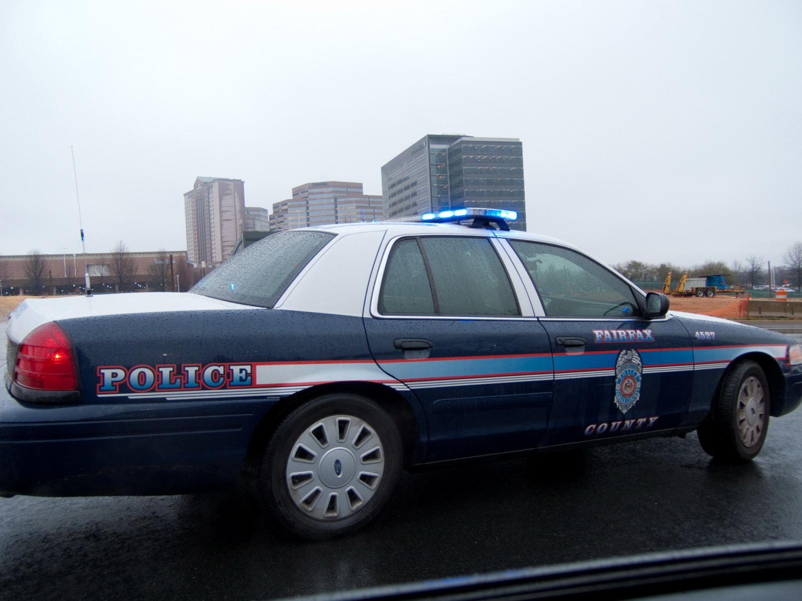 Fairfax County Police cruiser with emergency lights on a roadway.