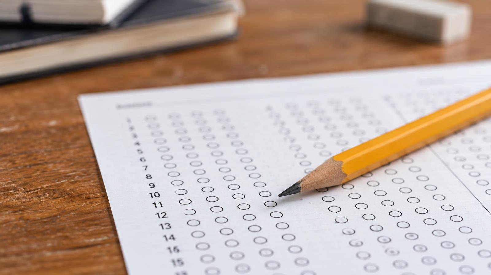 A sharpened pencil resting on a blank multiple-choice answer sheet