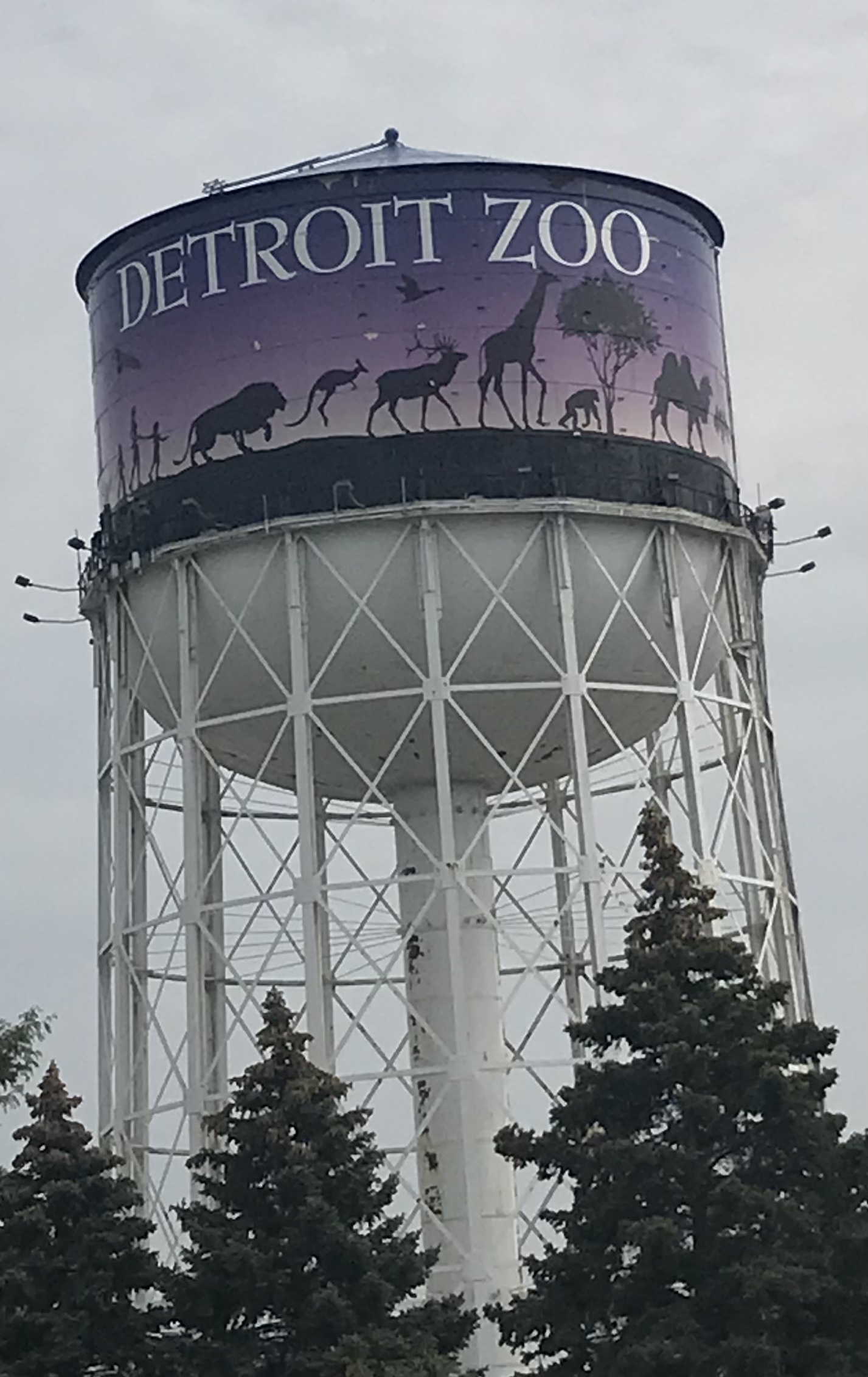 Tall white water tower painted with animal silhouettes and Detroit Zoo text.