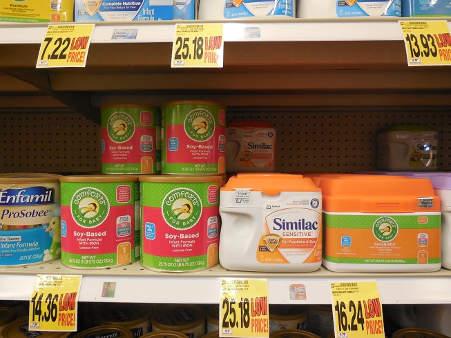 Cans of Similac infant formula displayed on a grocery store shelf.