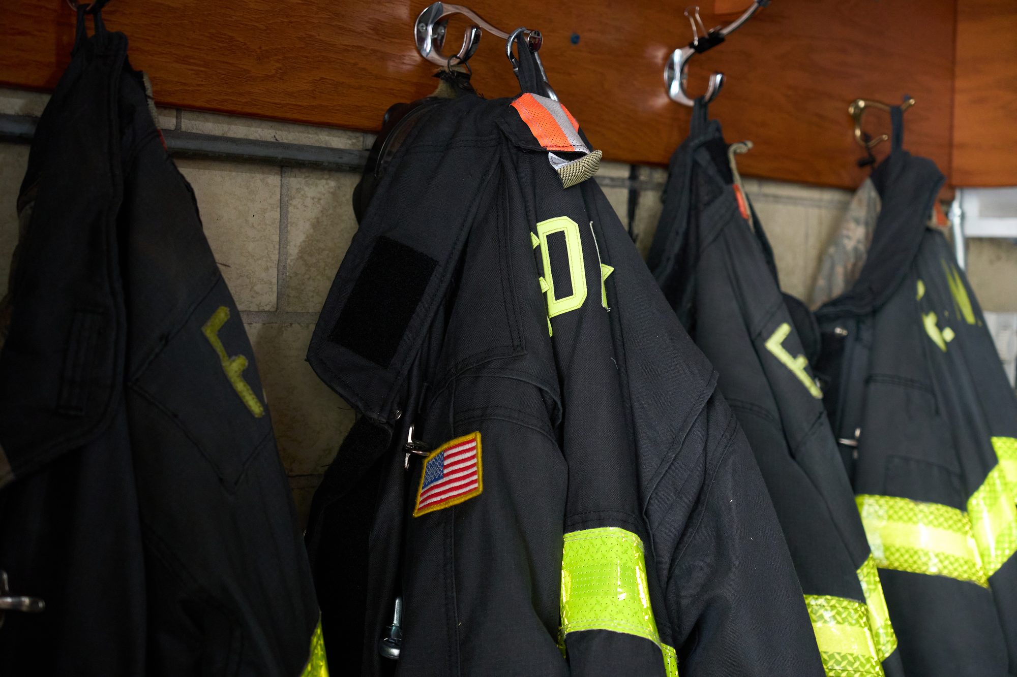 Firefighter jackets hanging in fire station locker room in new york city
