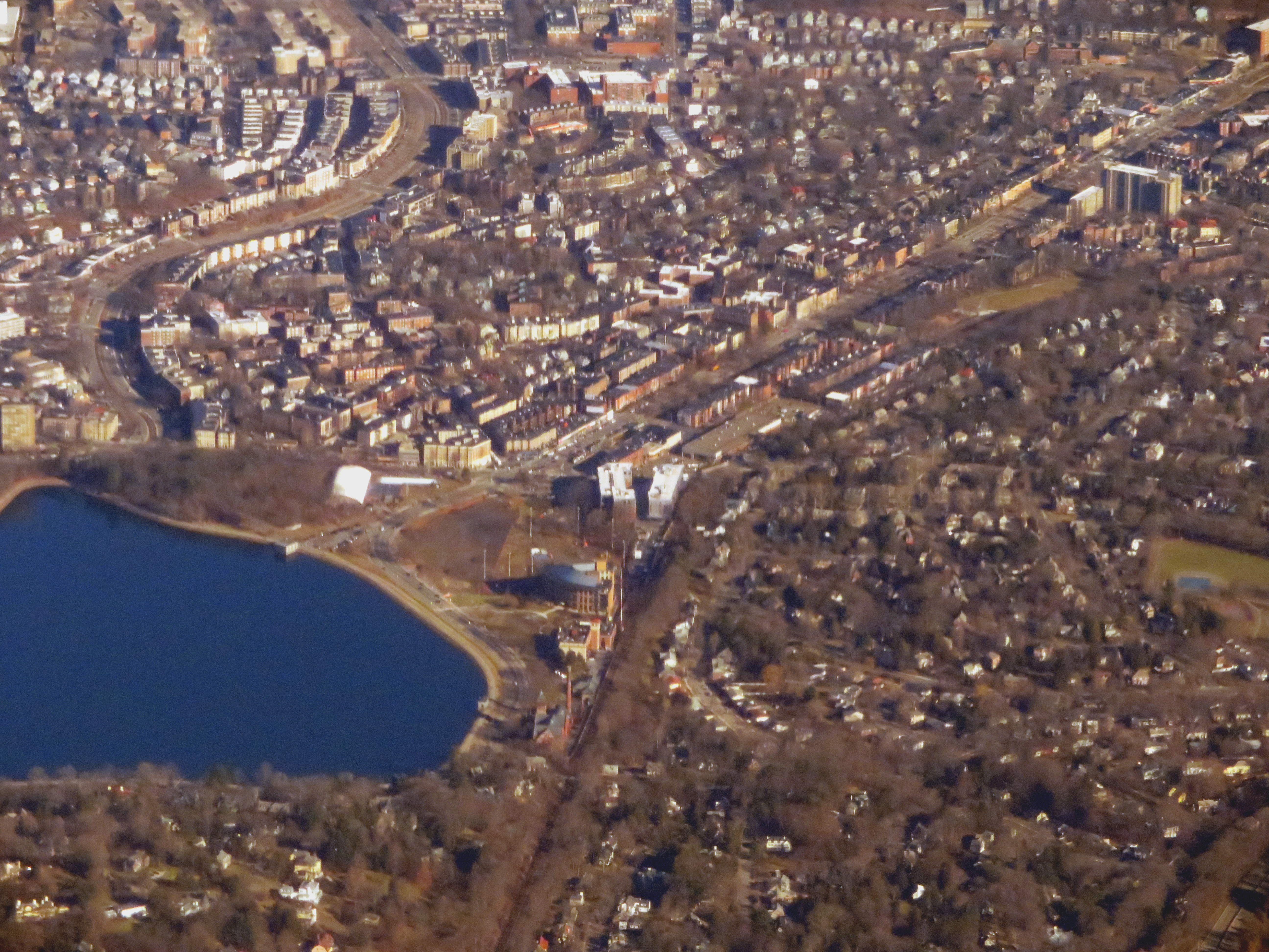 Aerial view of dense residential streets near a large urban reservoir.