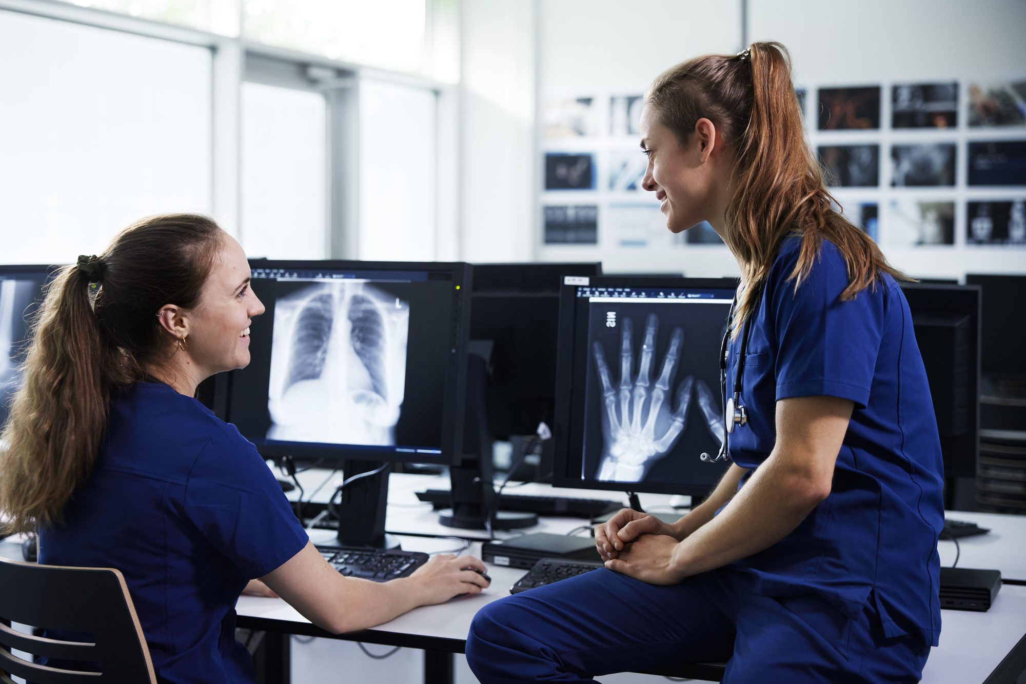 Two female healthcare professionals looking at x-ray scans