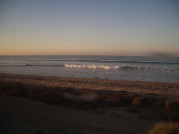 Sandy beach with breaking ocean waves along the Southern California coast.