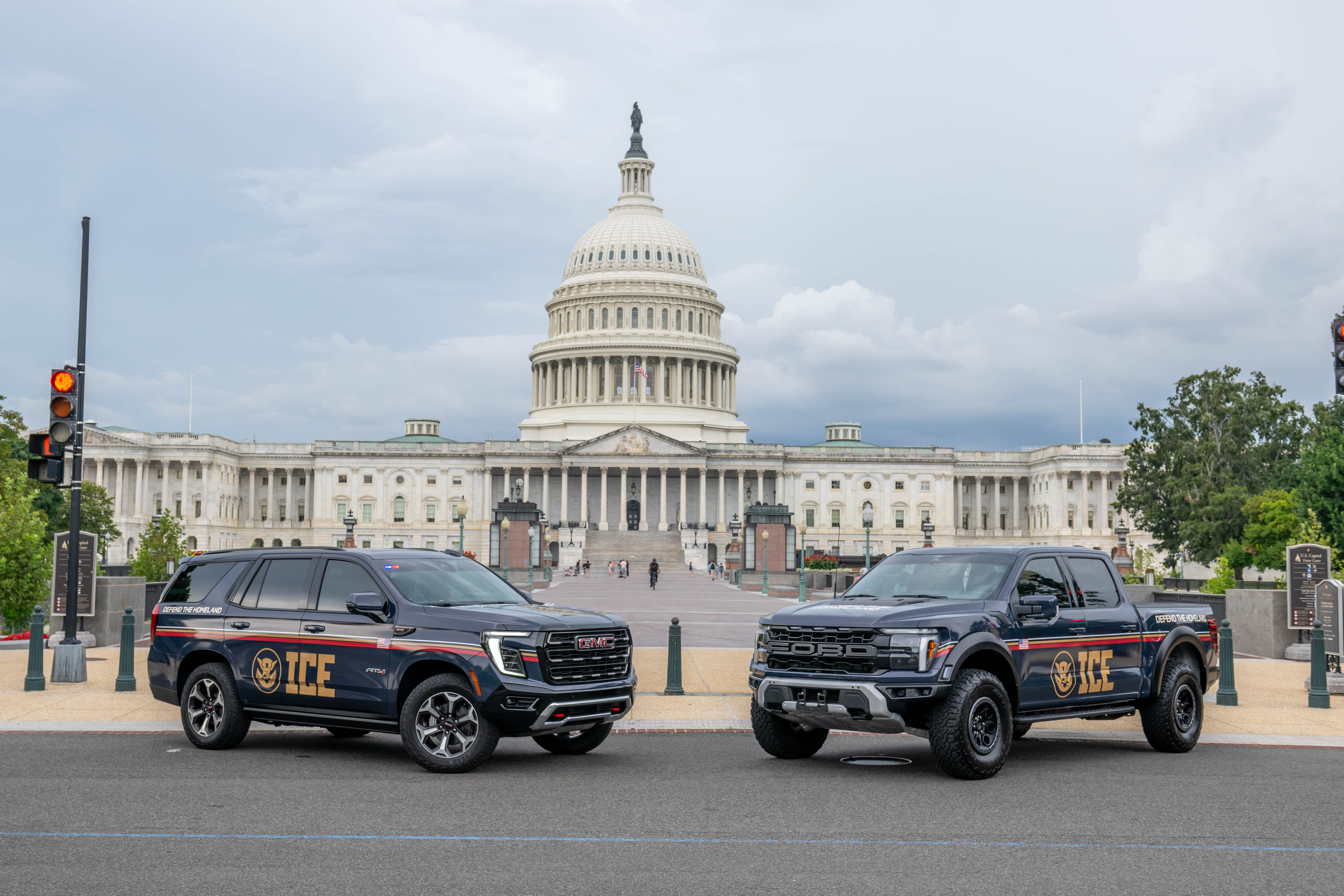 Two dark ICE-branded law enforcement vehicles parked outdoors.