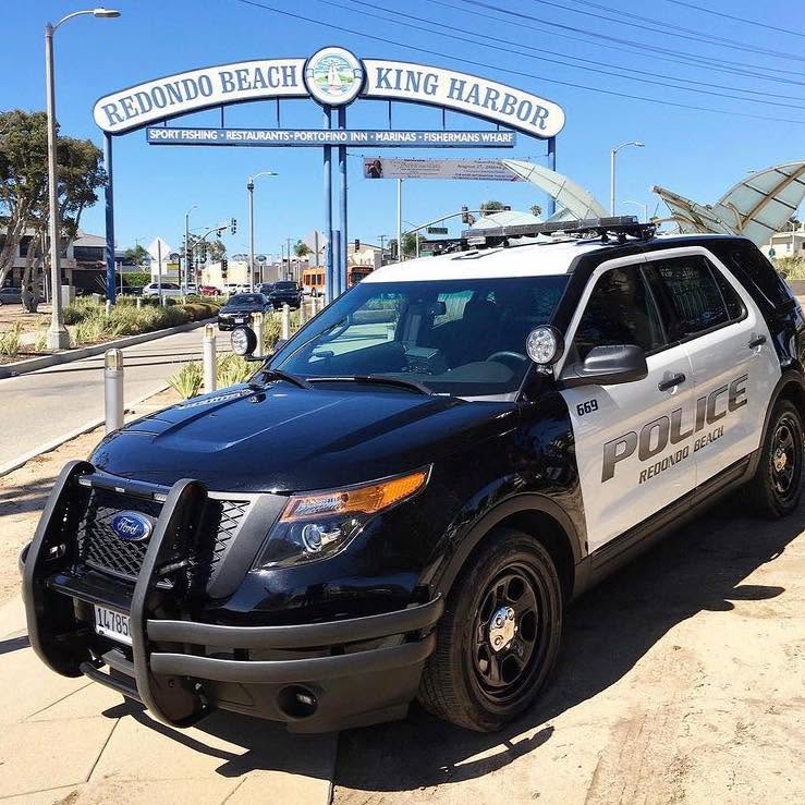 Redondo Beach police car in front of Redondo Beach King Harbor sign