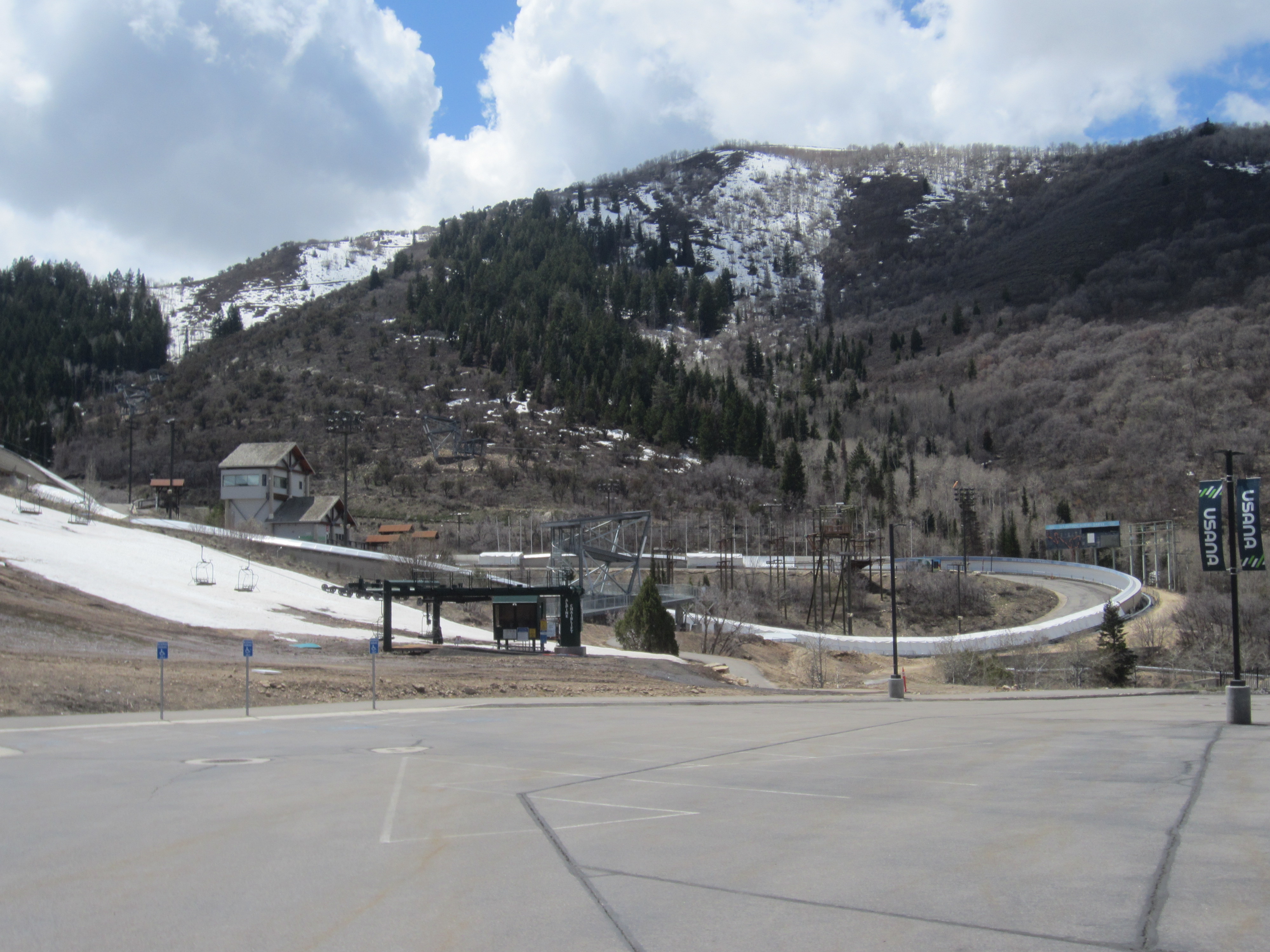 Ski jump ramps and bobsled track at a mountain sports facility in winter.