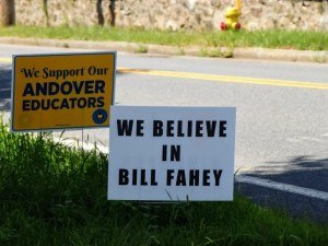 Two yard signs on grass, one reading 'We Believe in Bill Fahey' and another supporting Andover educators.