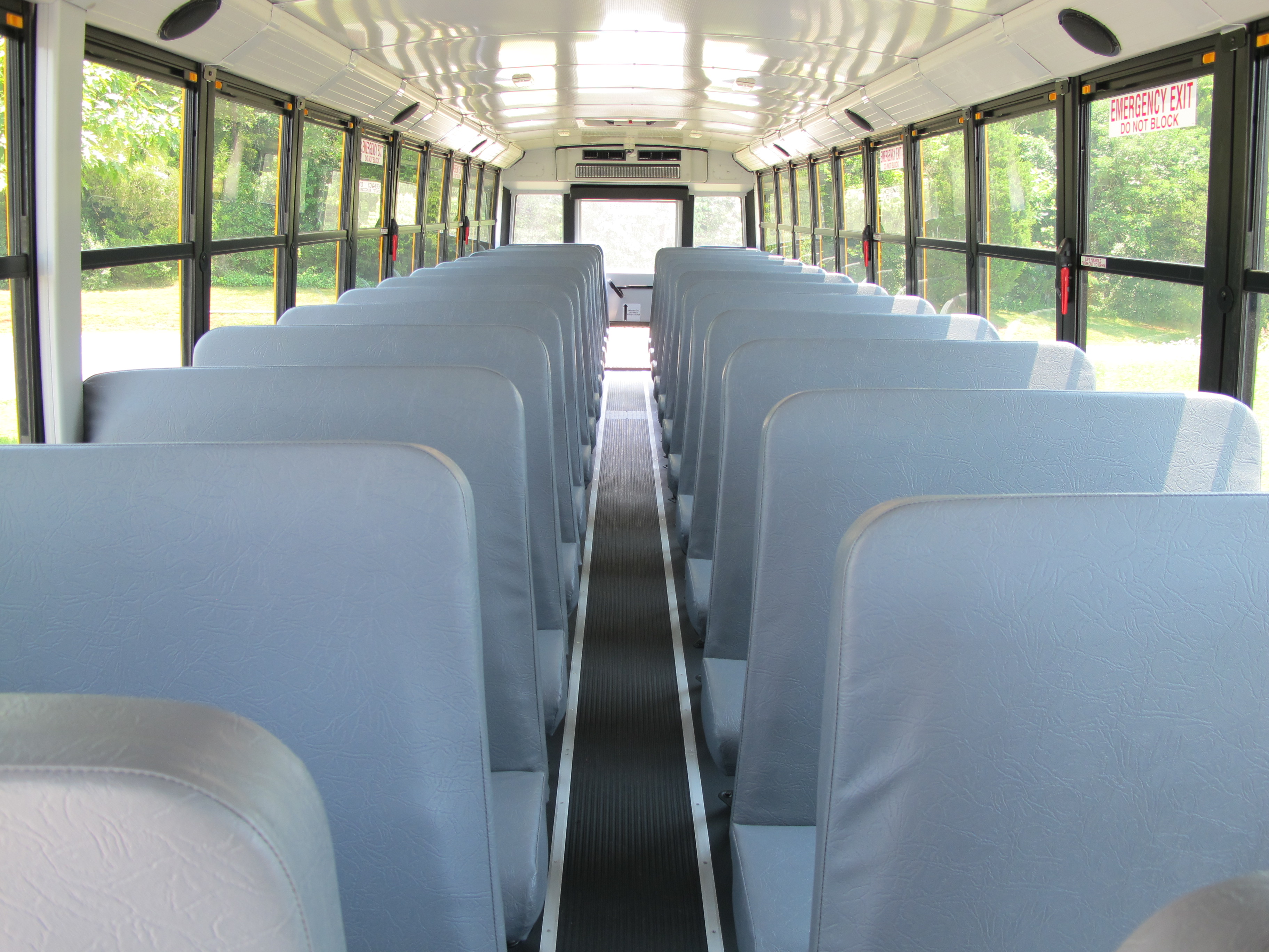 Interior of a school bus showing rows of padded seats and a center aisle.
