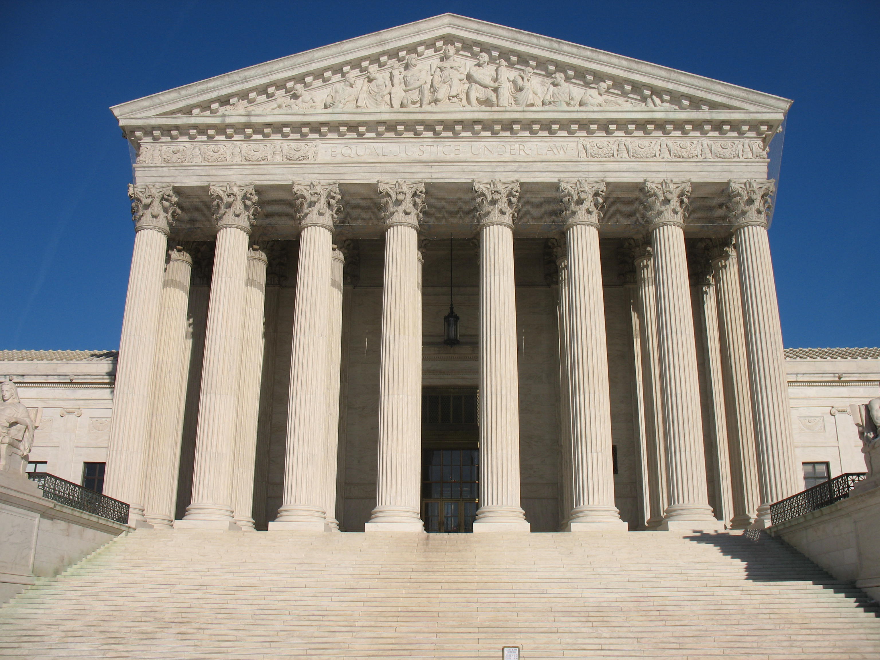 Neoclassical facade of the U.S. Supreme Court building with eight Corinthian columns and marble steps.