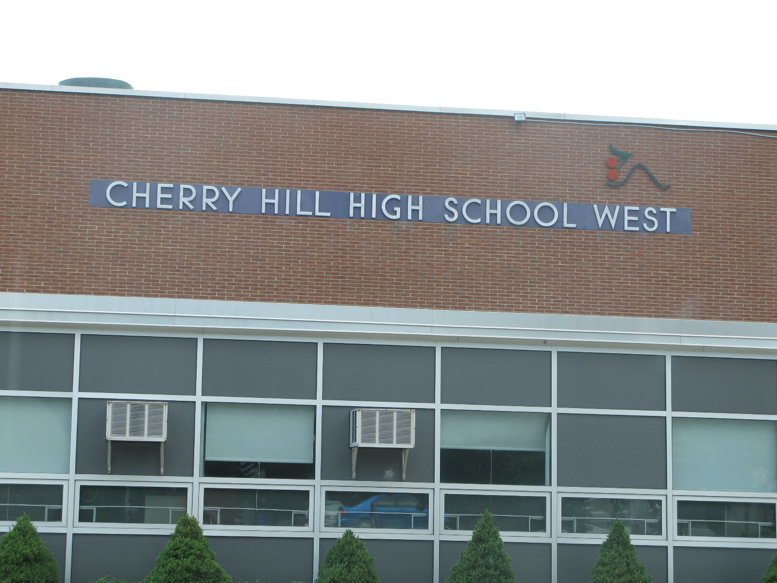 Brick school building facade with large sign reading Cherry Hill High School West.