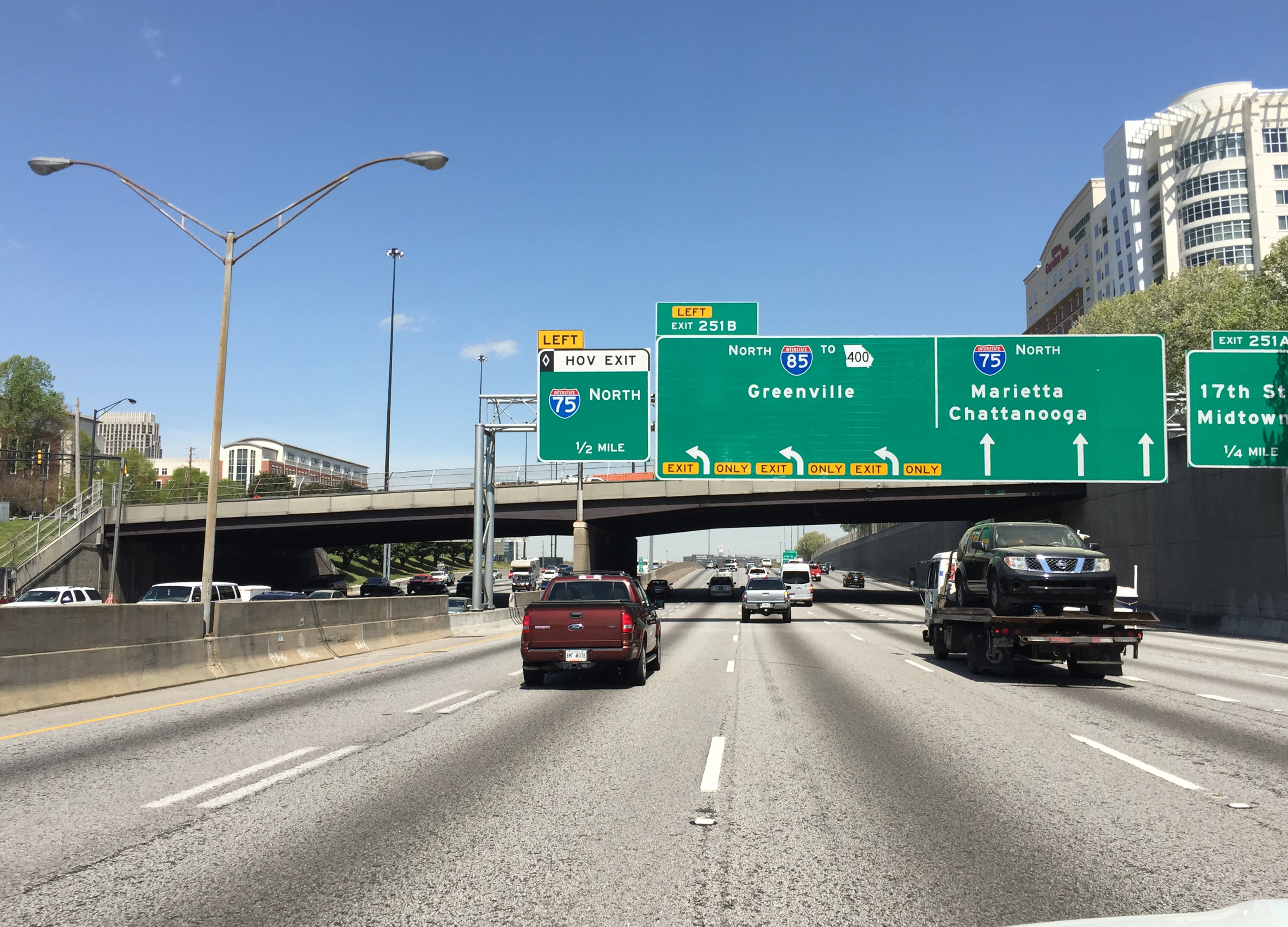 Multi-lane Atlanta interstate with overhead green highway signs and light traffic.