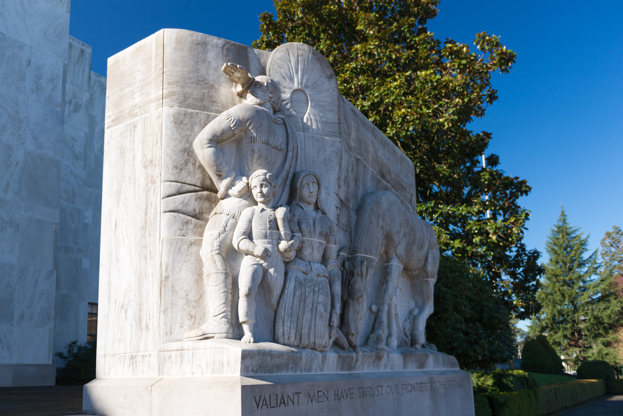 Large stone relief sculpture of pioneer figures on the Oregon State Capitol grounds.
