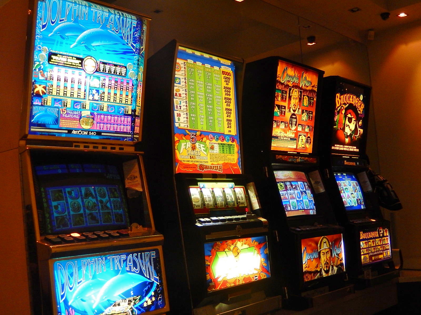 Rows of illuminated slot machines inside a gaming venue.