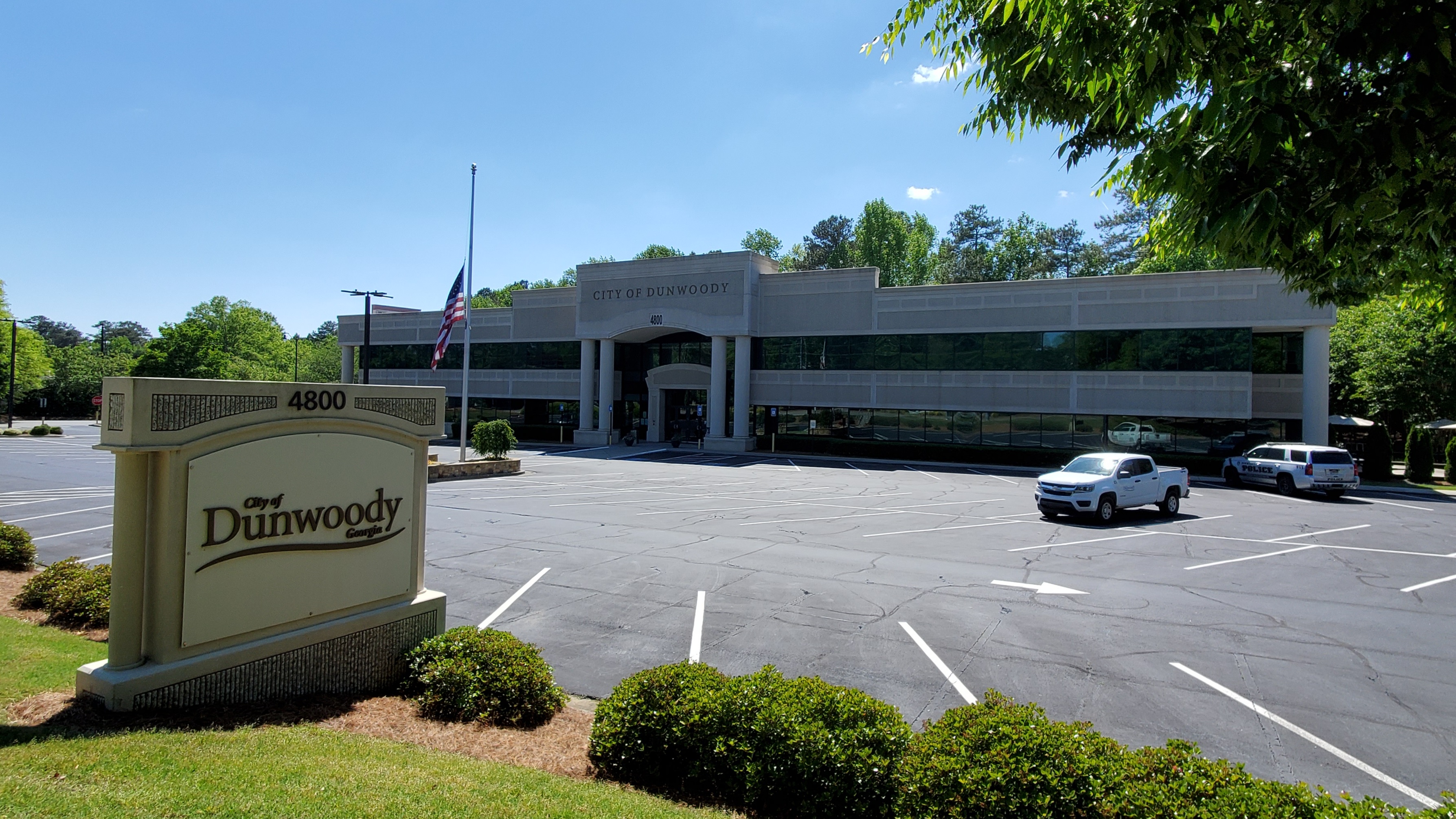 Two-story glass and brick building with a City of Dunwoody sign out front.