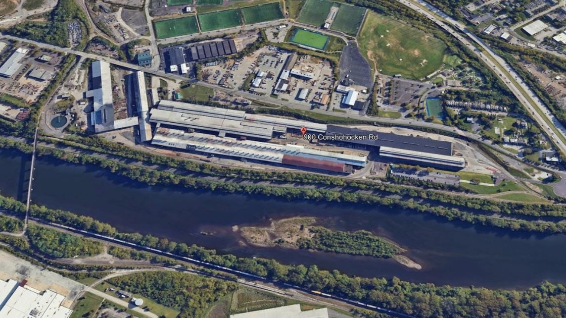 Aerial satellite view of a large industrial complex along a river, labeled 900 Conshohocken Rd.