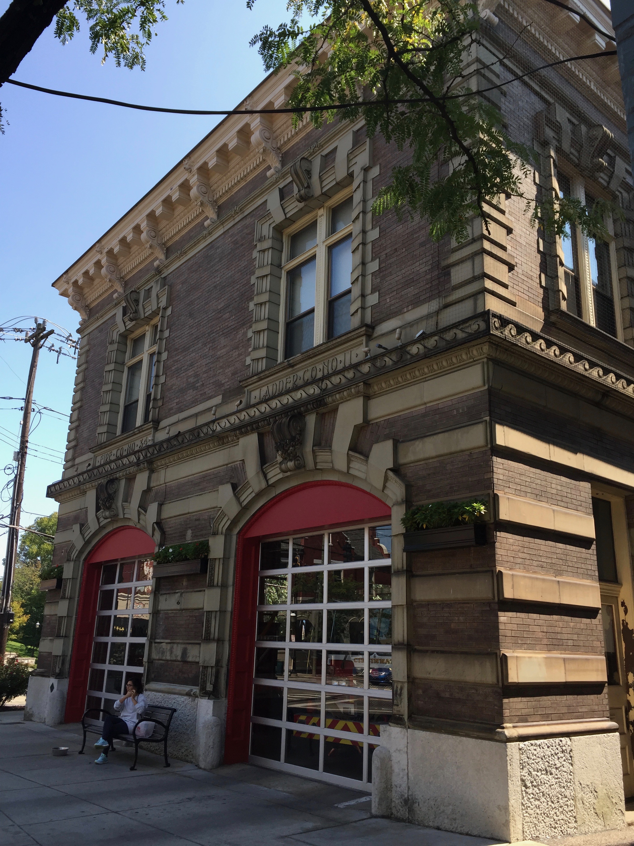 Brick fire station exterior with two large red arched garage doors.