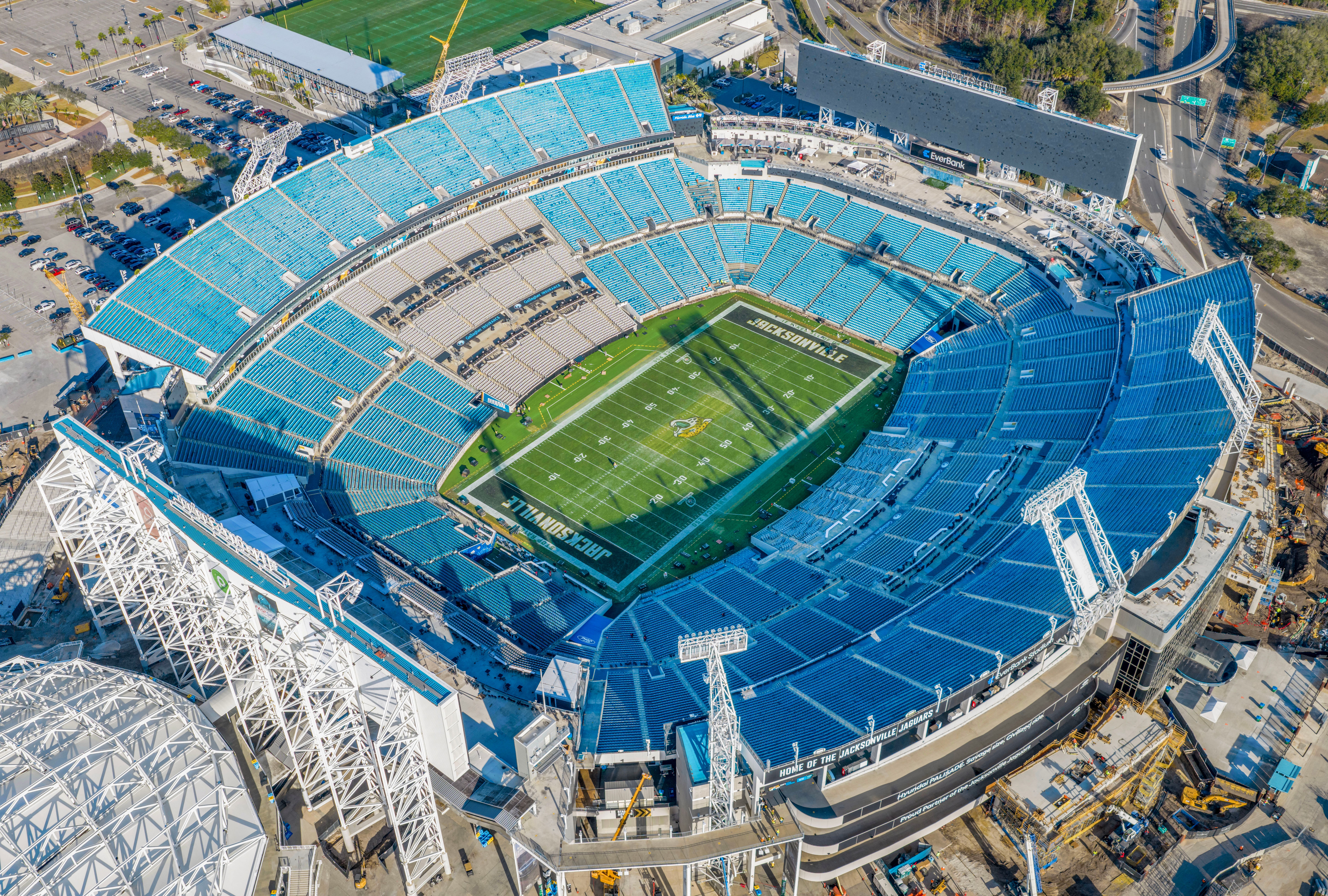 Aerial view of a large NFL stadium with teal seating and a green playing field.