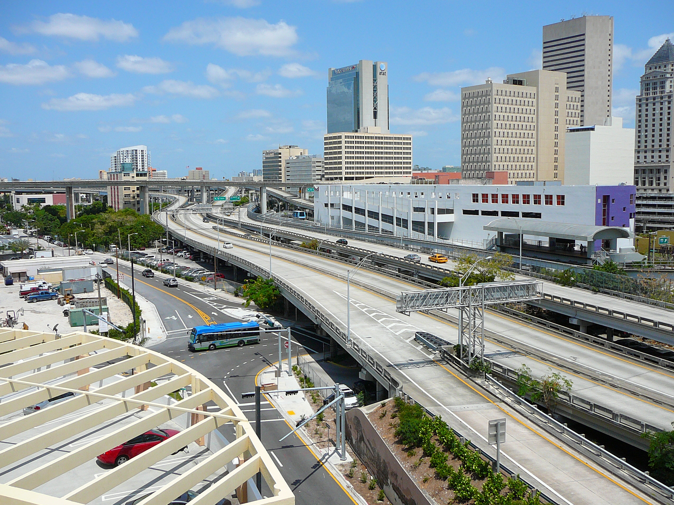 Aerial view of downtown Miami's elevated roadway and Metromover rail with city skyline.
