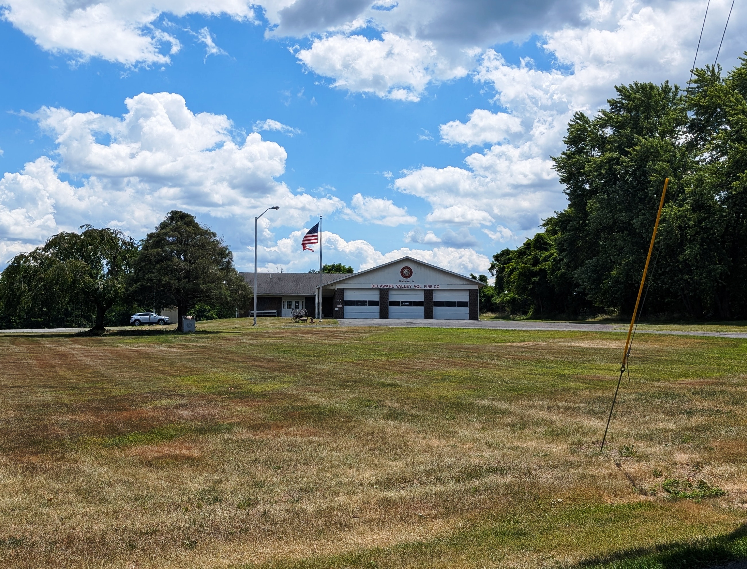 Single-story volunteer fire station with multiple garage bays and an American flag.