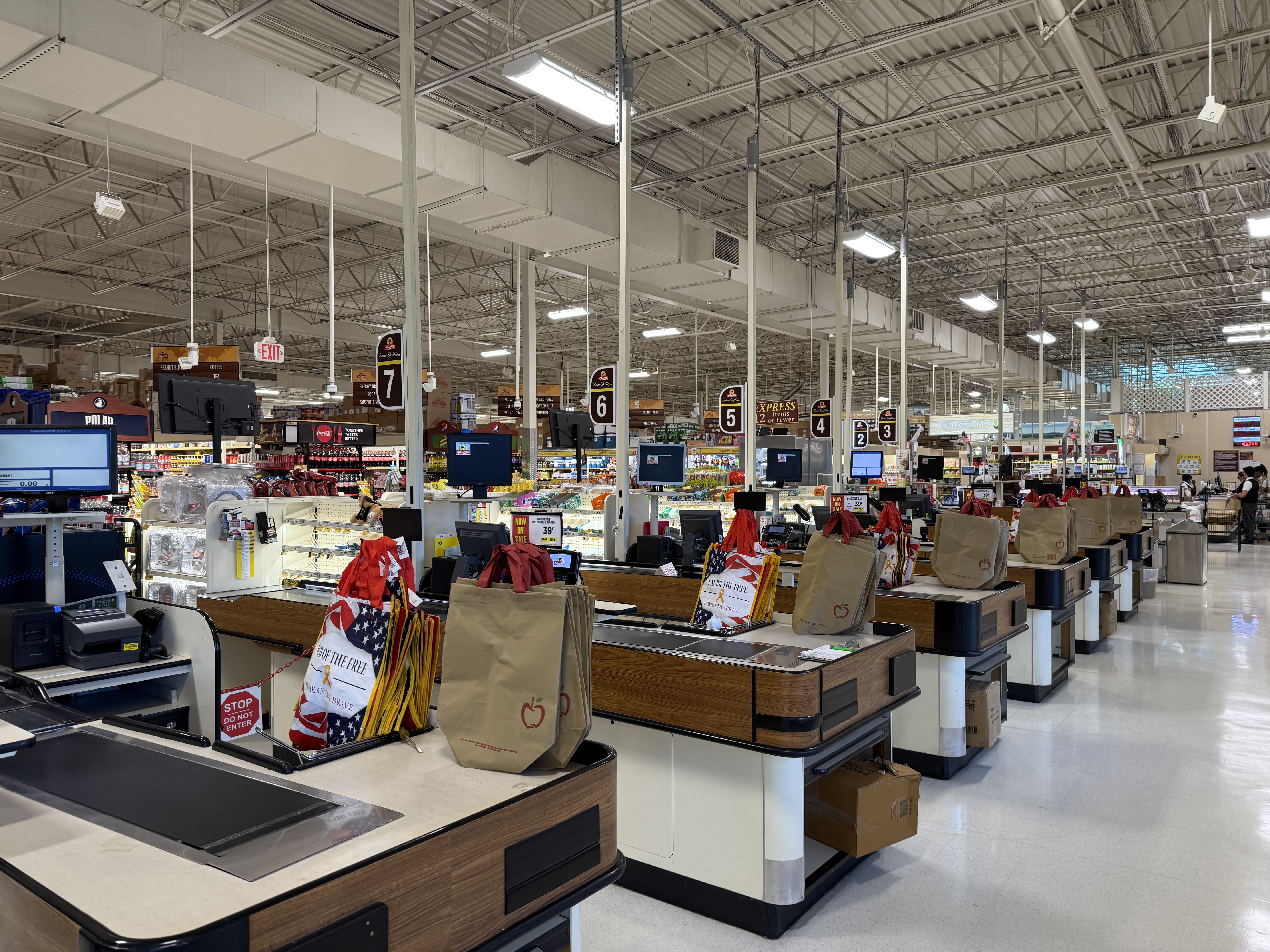 Rows of checkout lanes inside a ShopRite grocery store.