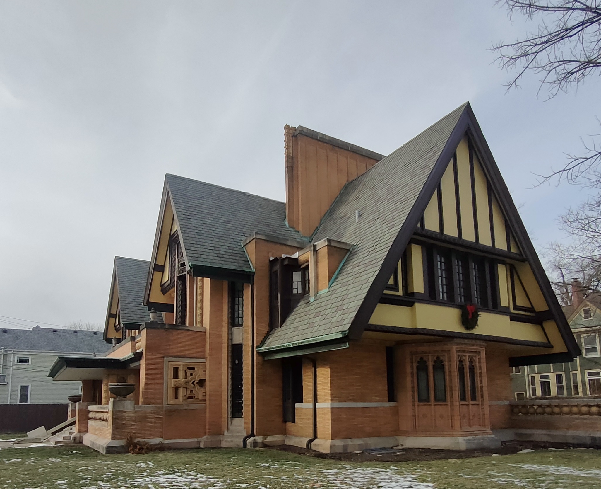 A large Tudor Revival brick house with steeply pitched gabled roofs and half-timbering.