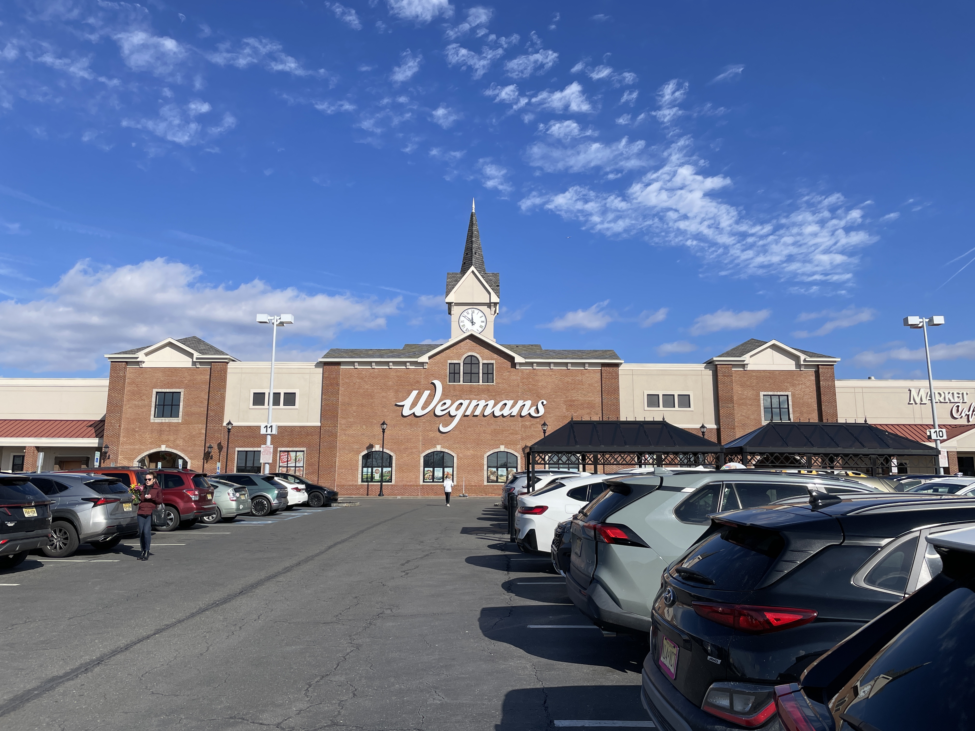 Exterior of a Wegmans grocery store with a brick facade and clock tower.