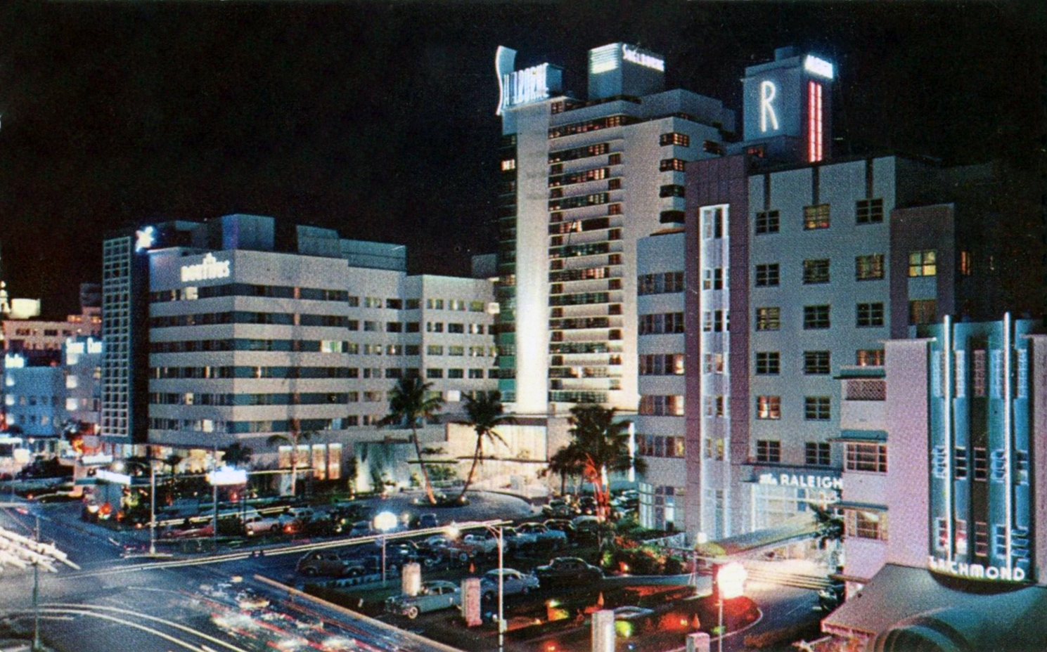 Vintage nighttime postcard of Collins Avenue with illuminated hotel signs and street traffic.