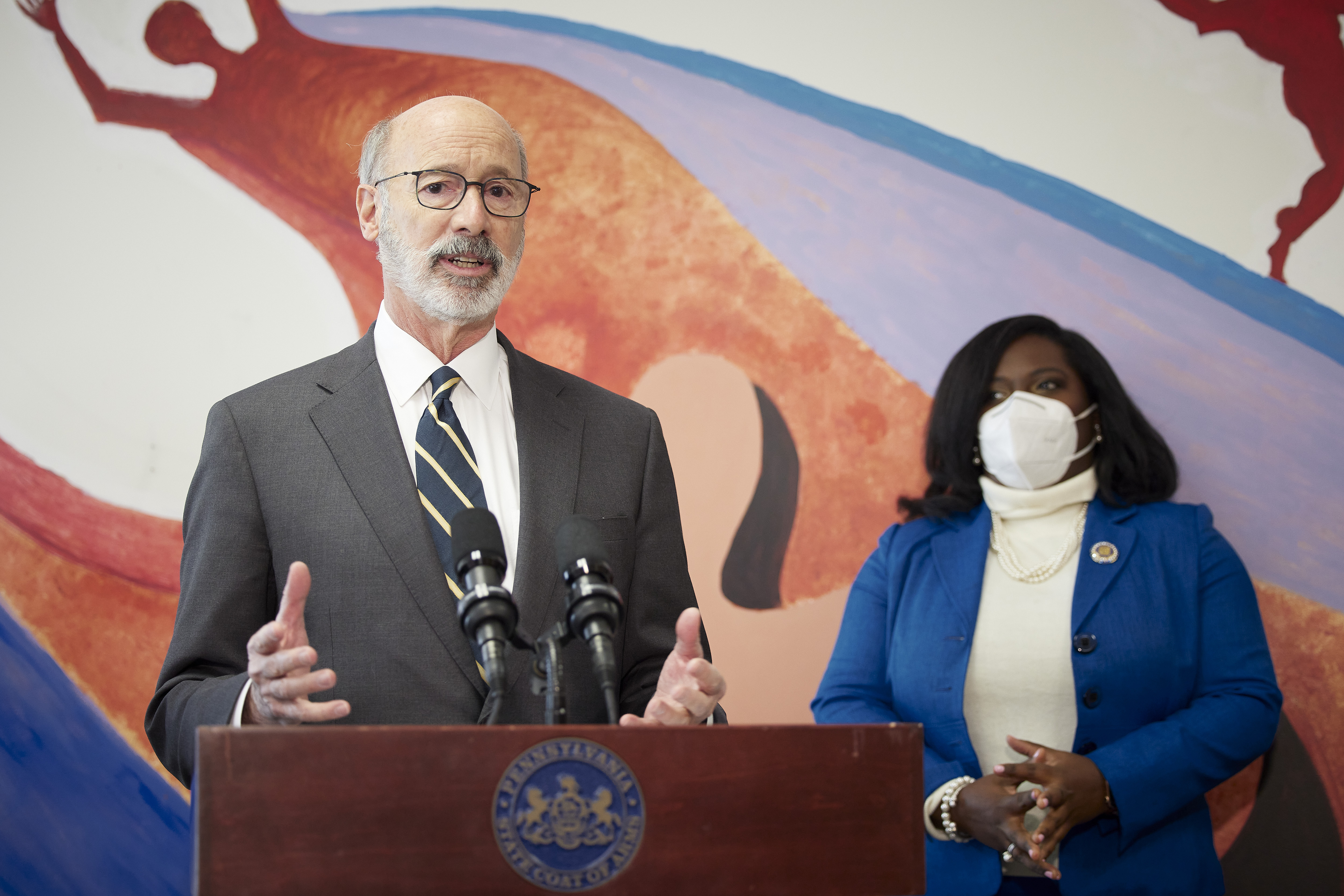 A man in a suit speaks at a podium bearing the Pennsylvania state seal.