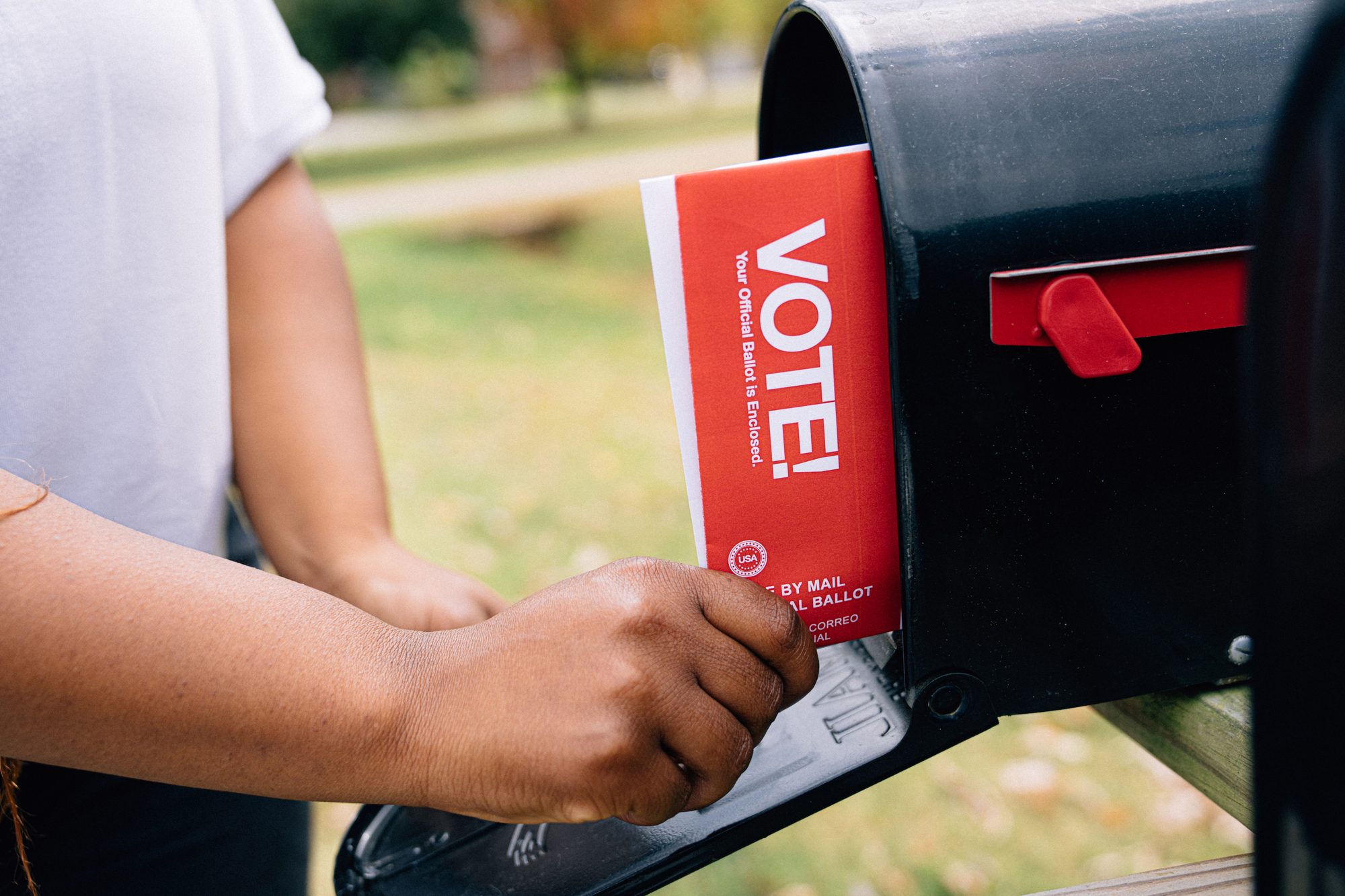 Close-up shot of a Black woman's hands receiving a mail-in ballot to vote in a USA Presidential, Senatorial, Congressional, or local election