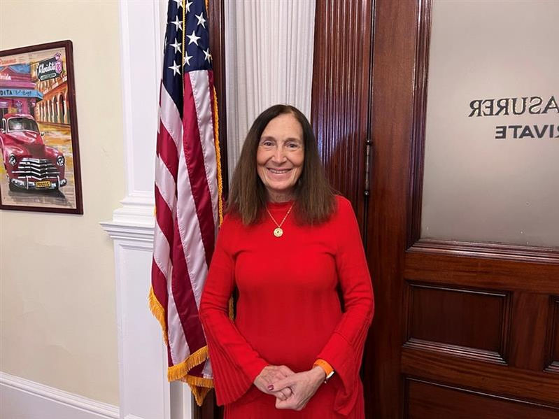 Treasurer Goldberg in front of an American flag.