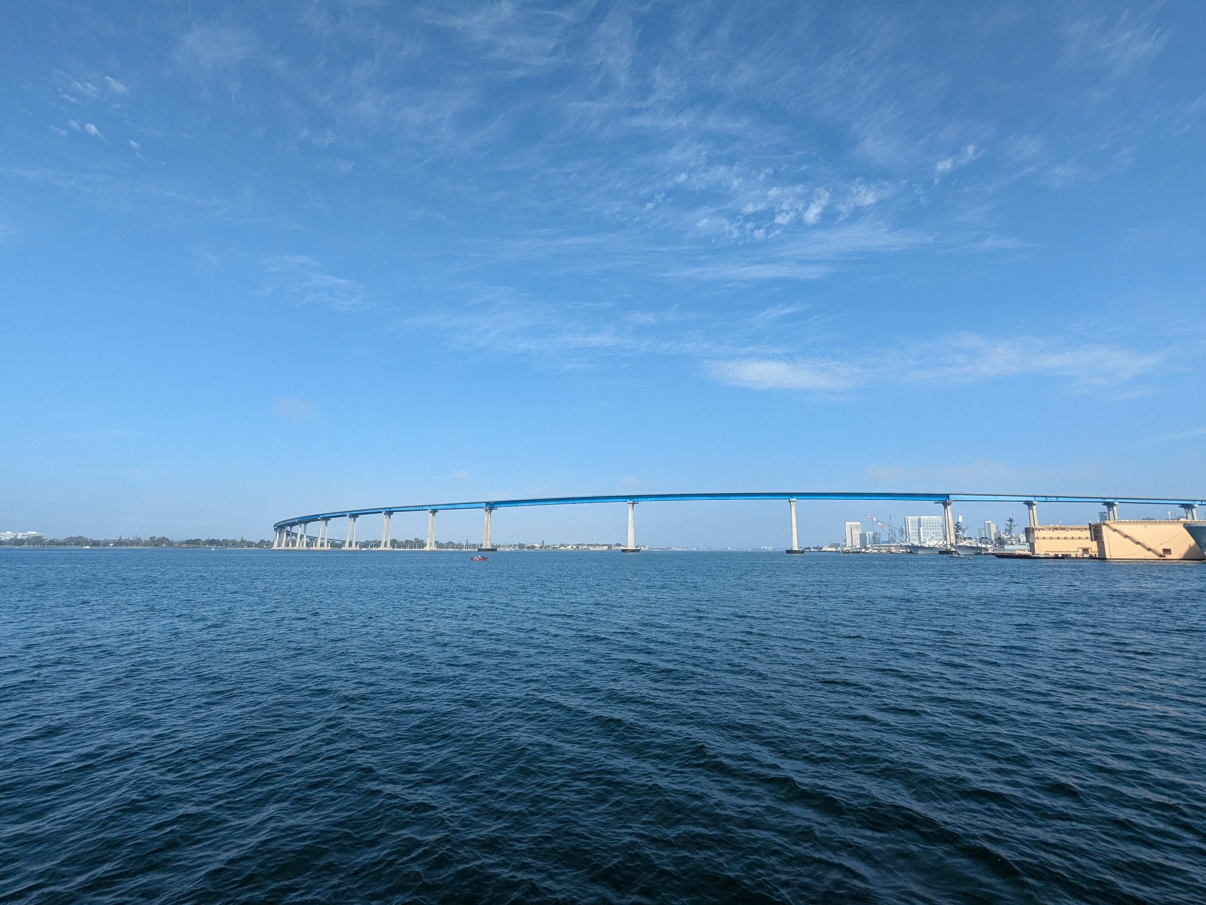 The Coronado Bridge spanning San Diego Bay, viewed from a boat on the water.