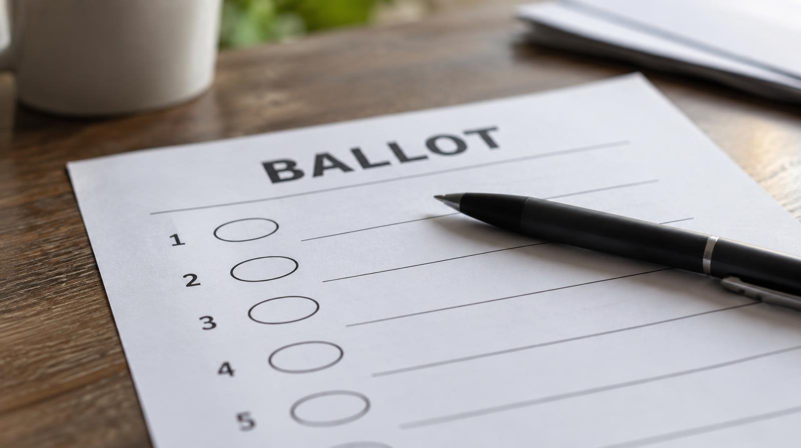 A blank paper ballot with oval bubbles beside numbered items and a black pen resting across it.
